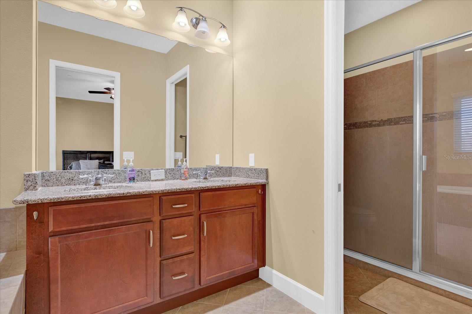 Dual-sink vanity and separate walk-in shower complete the primary bath.