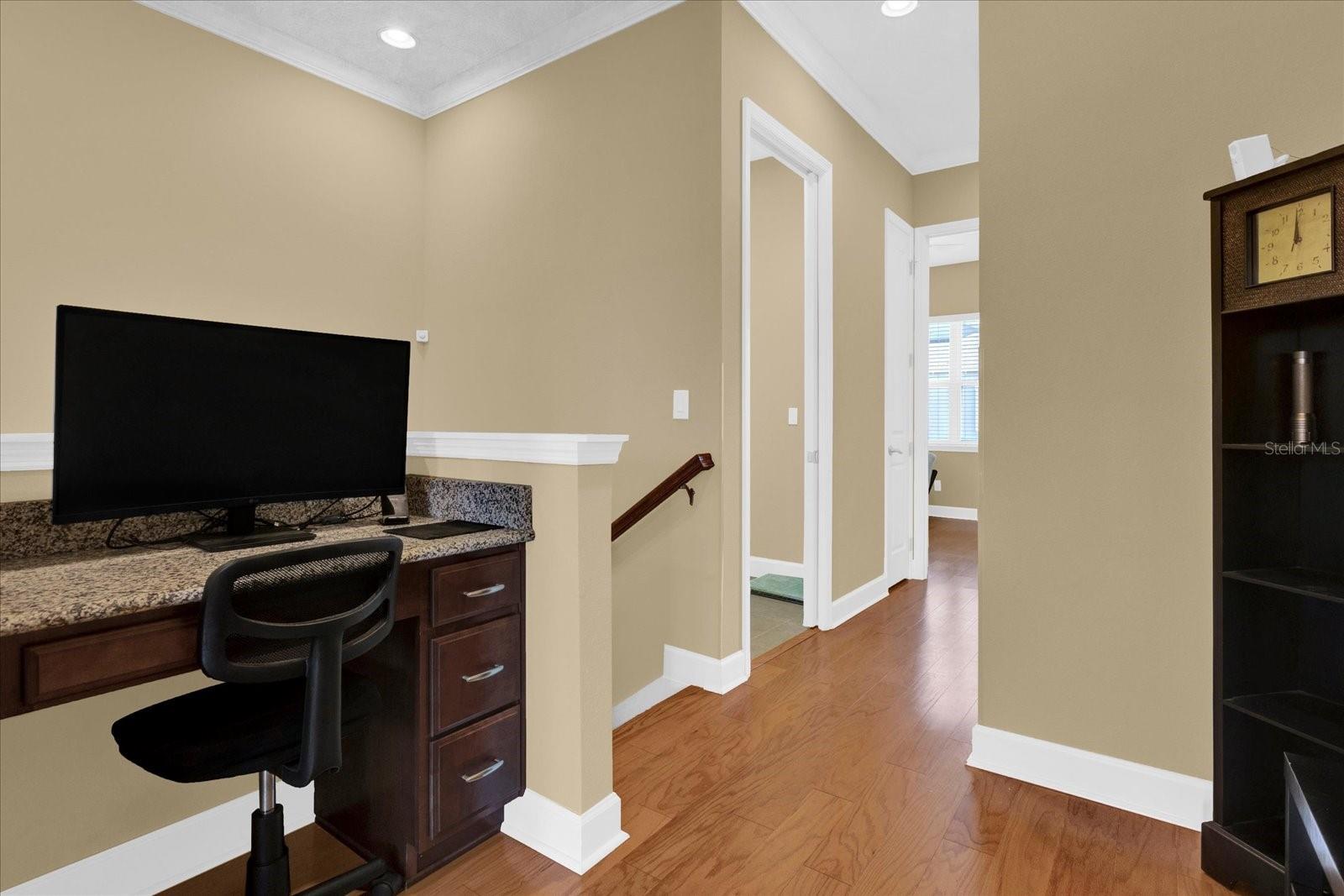 Built-in workstation nook at the entrance to the primary suite  perfect for a compact home office or study spot.