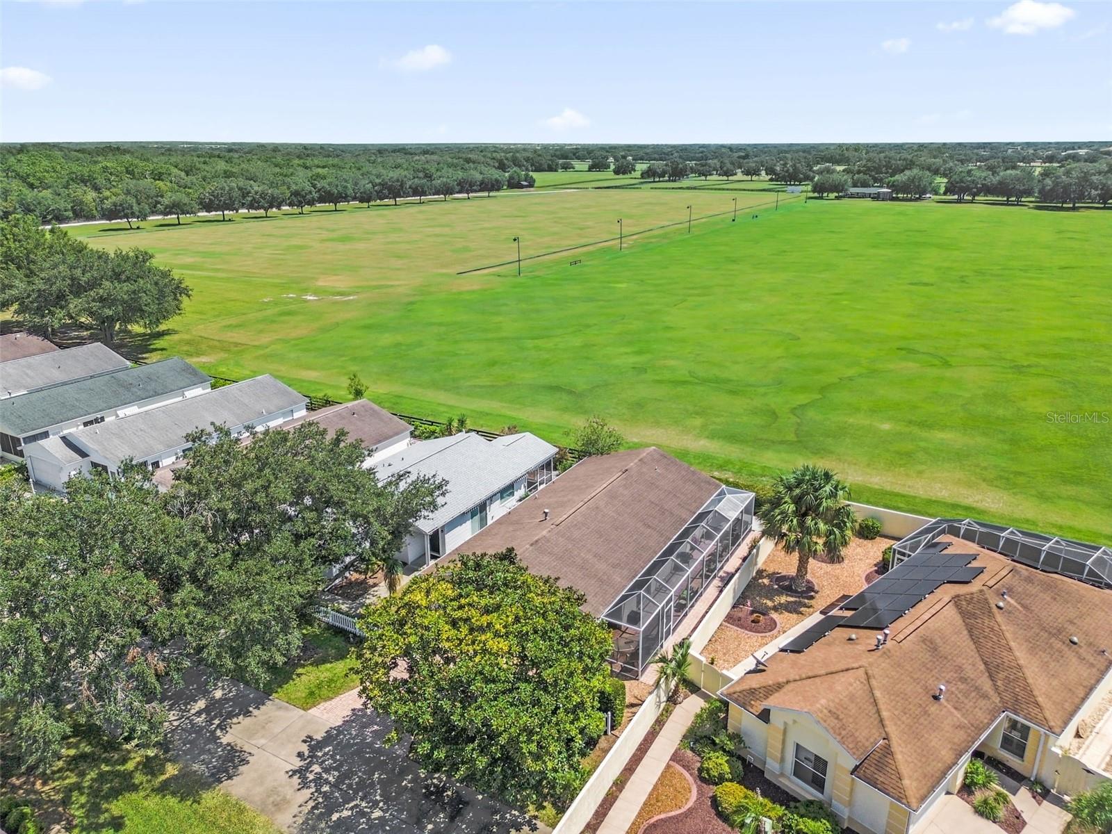 Drone view showcasing the home and the adjacent polo field.