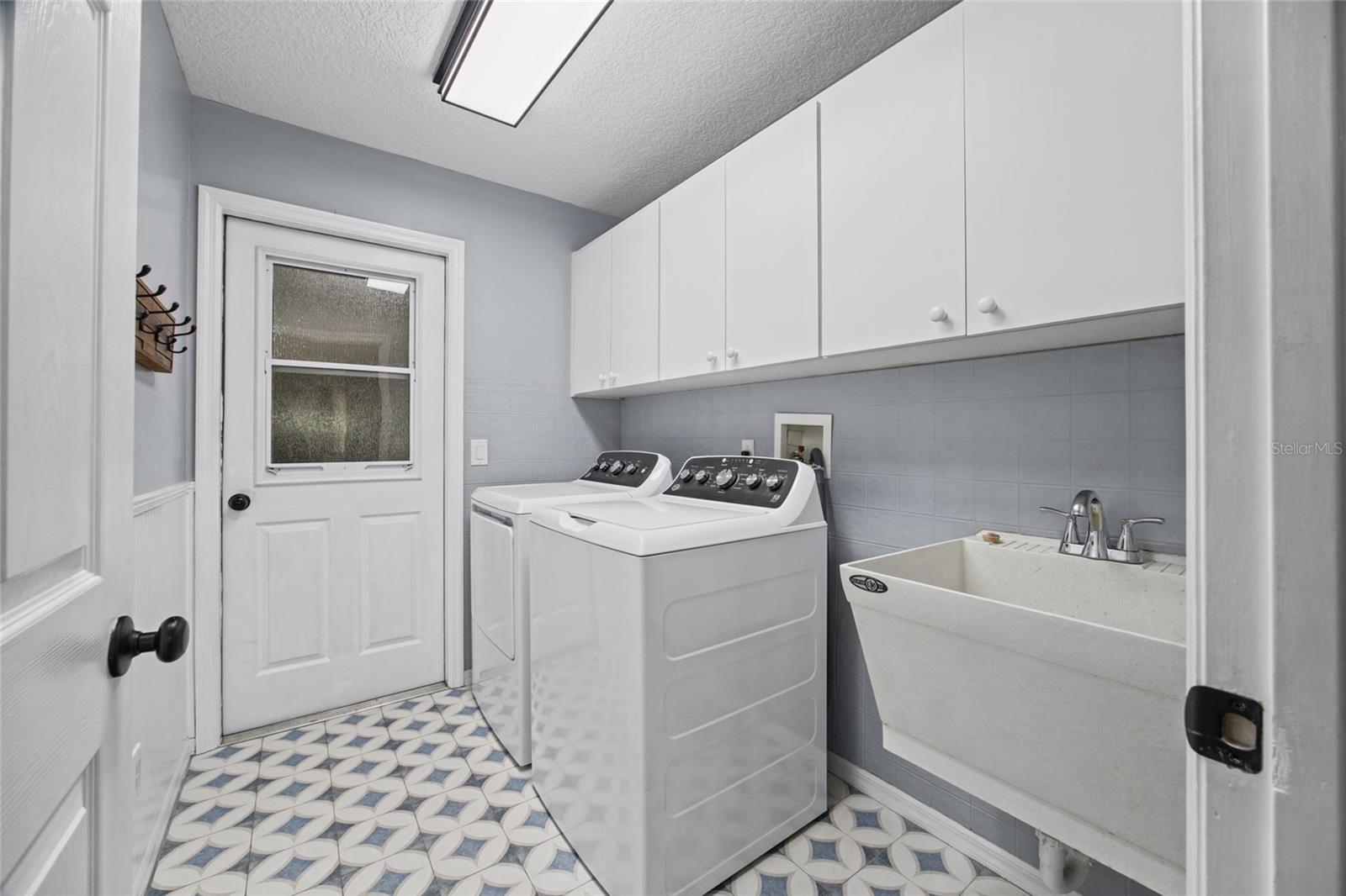 Inside Laundry room with storage closet, cabinets and sink