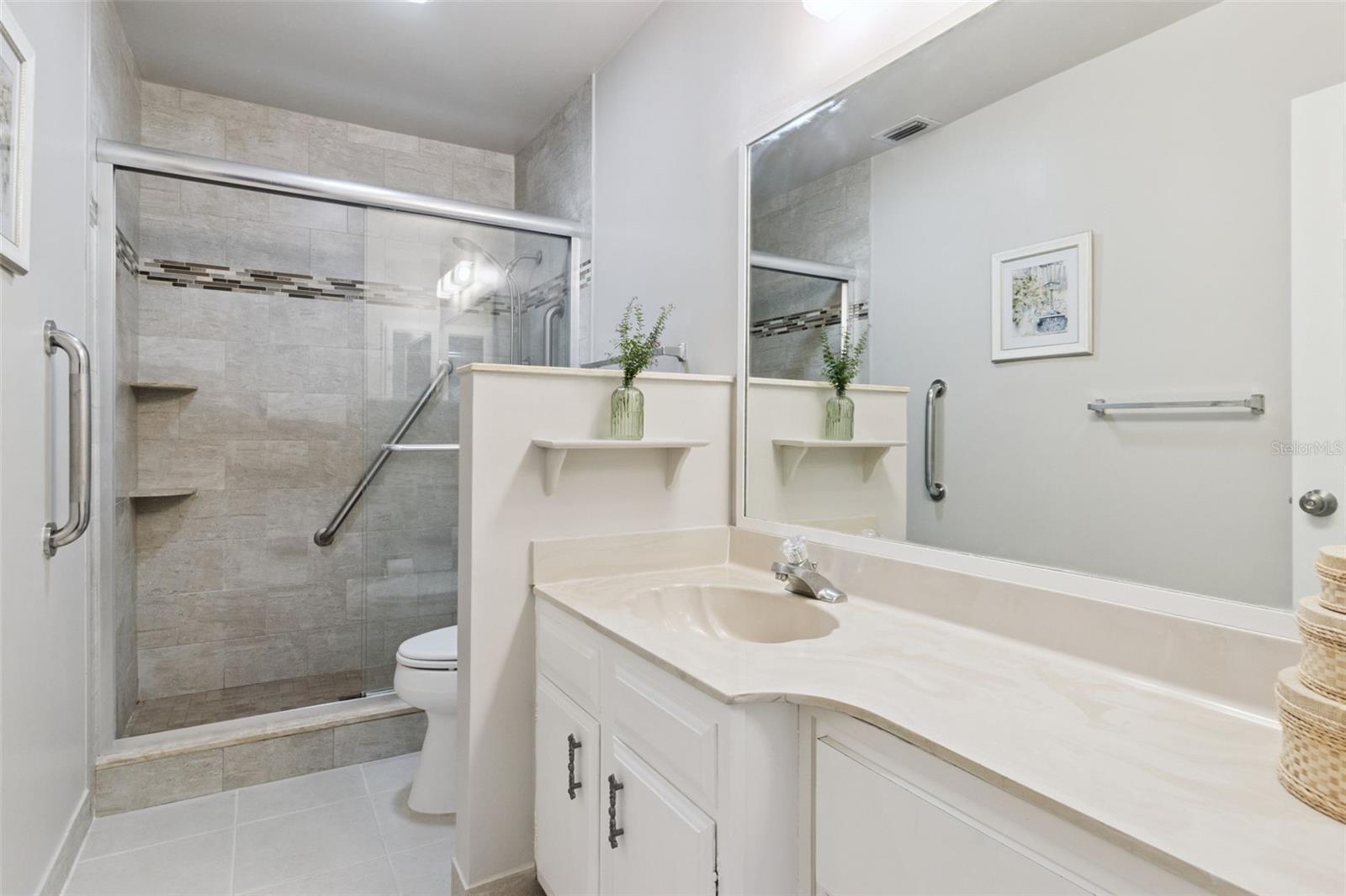 Spacious en suite bath with wide marble vanity, multiple drawers and ceramic tile flooring. Spacious en suite bath with wide marble vanity, multiple drawers and ceramic tile flooring.