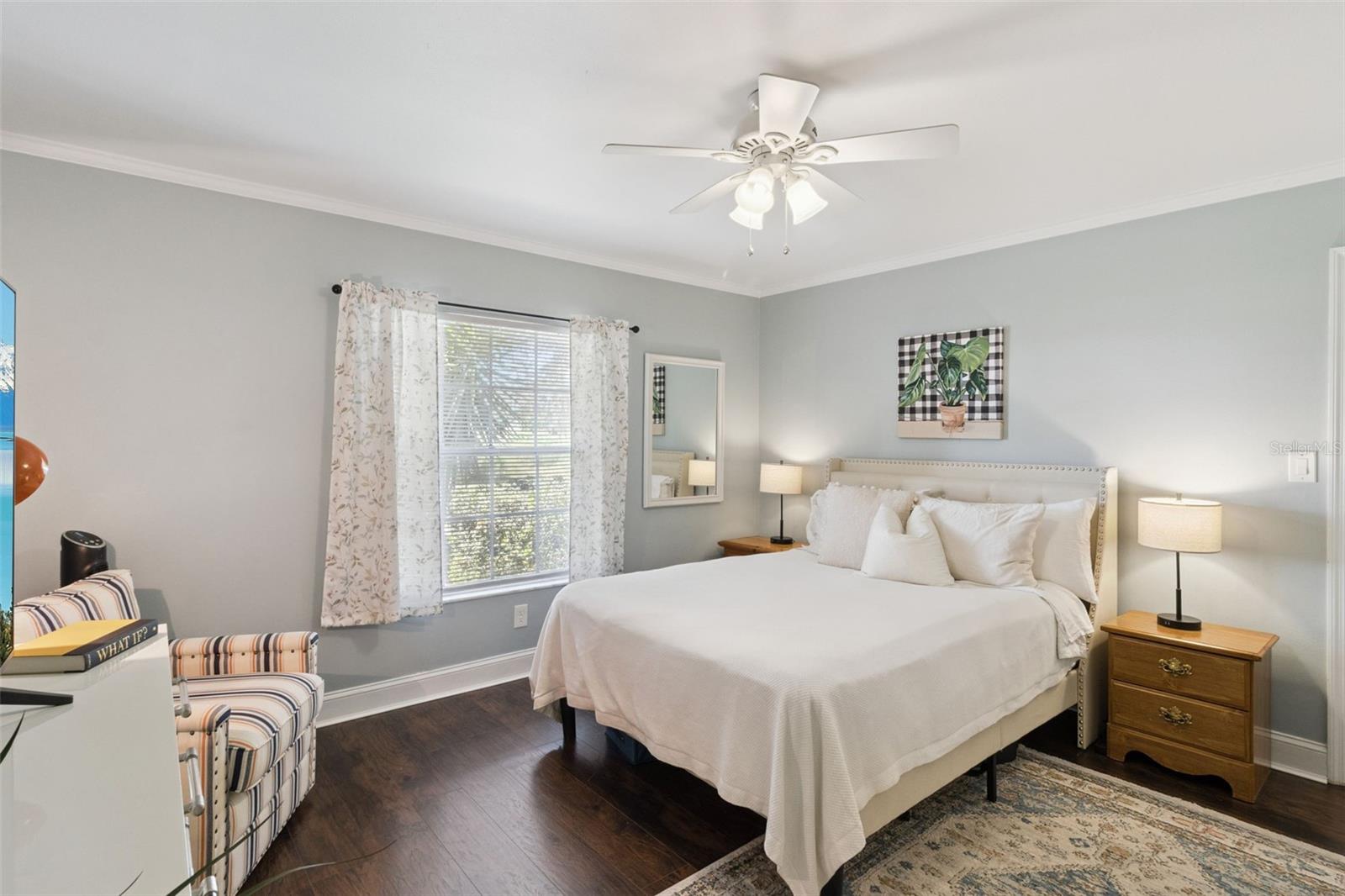 Crown molding and ceiling fan with lights plus no carpet are in the primary bedroom retreat.