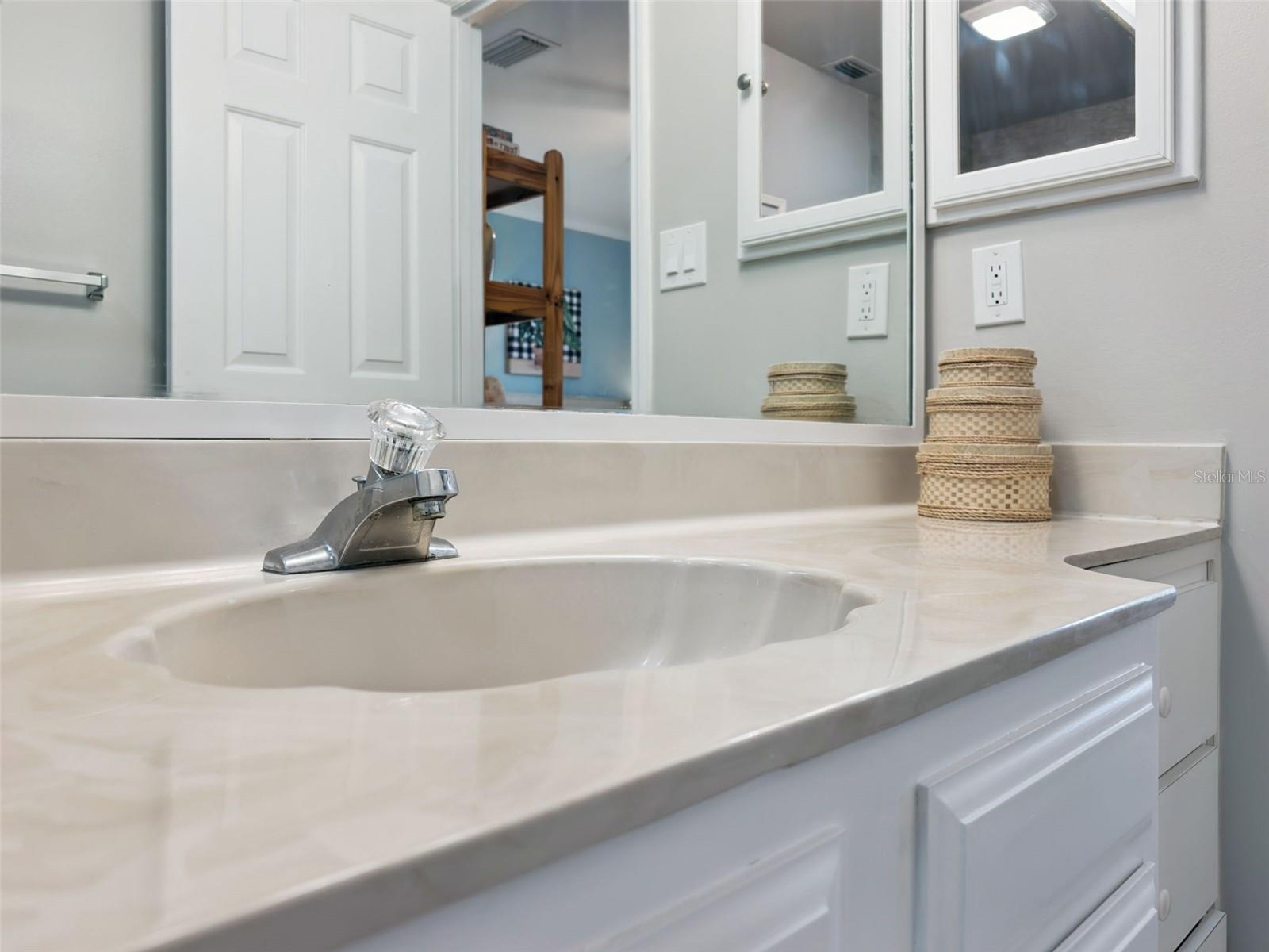 Spacious en suite bath features an easy-clean integral sink.