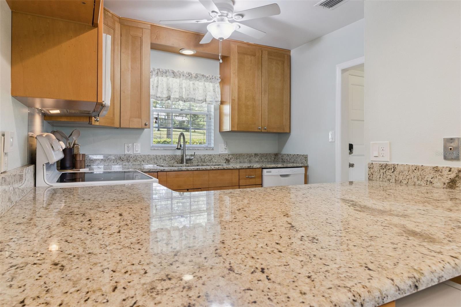 Abundant granite gleams throughout the kitchen.