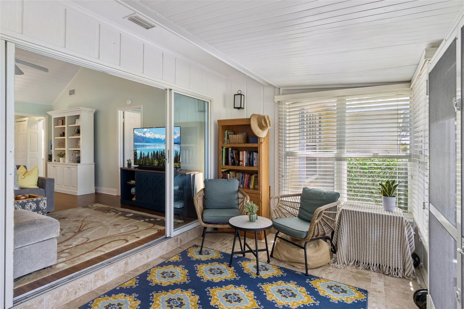 Open the four-panel sliding glass doors to the sunroom.