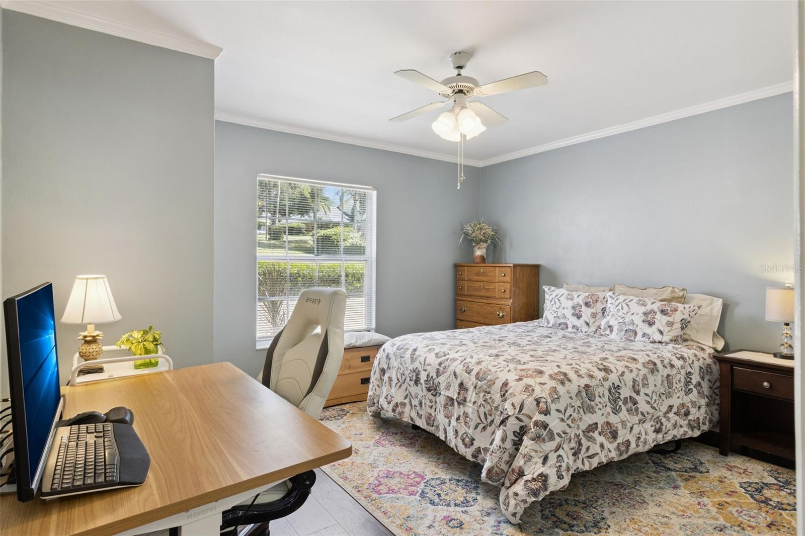 Secondary bedroom also has crown molding and ceiling fan with lights.