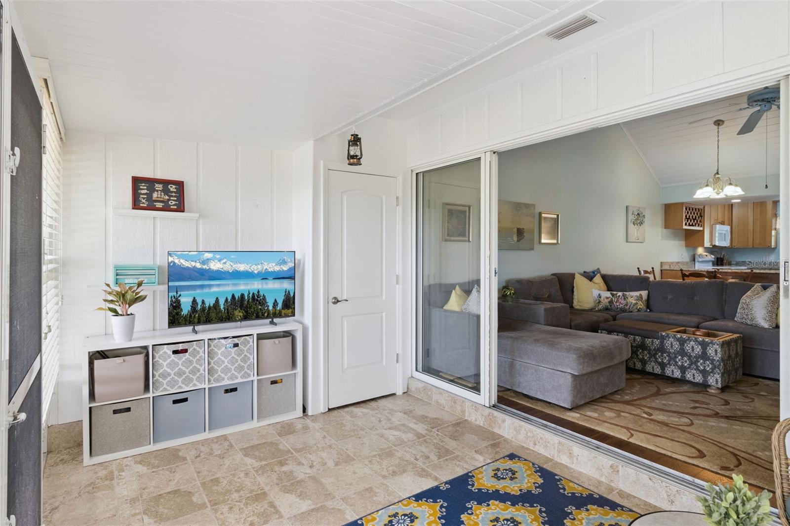 Sunroom has stunning custom tile flooring and a handy storage closet.
