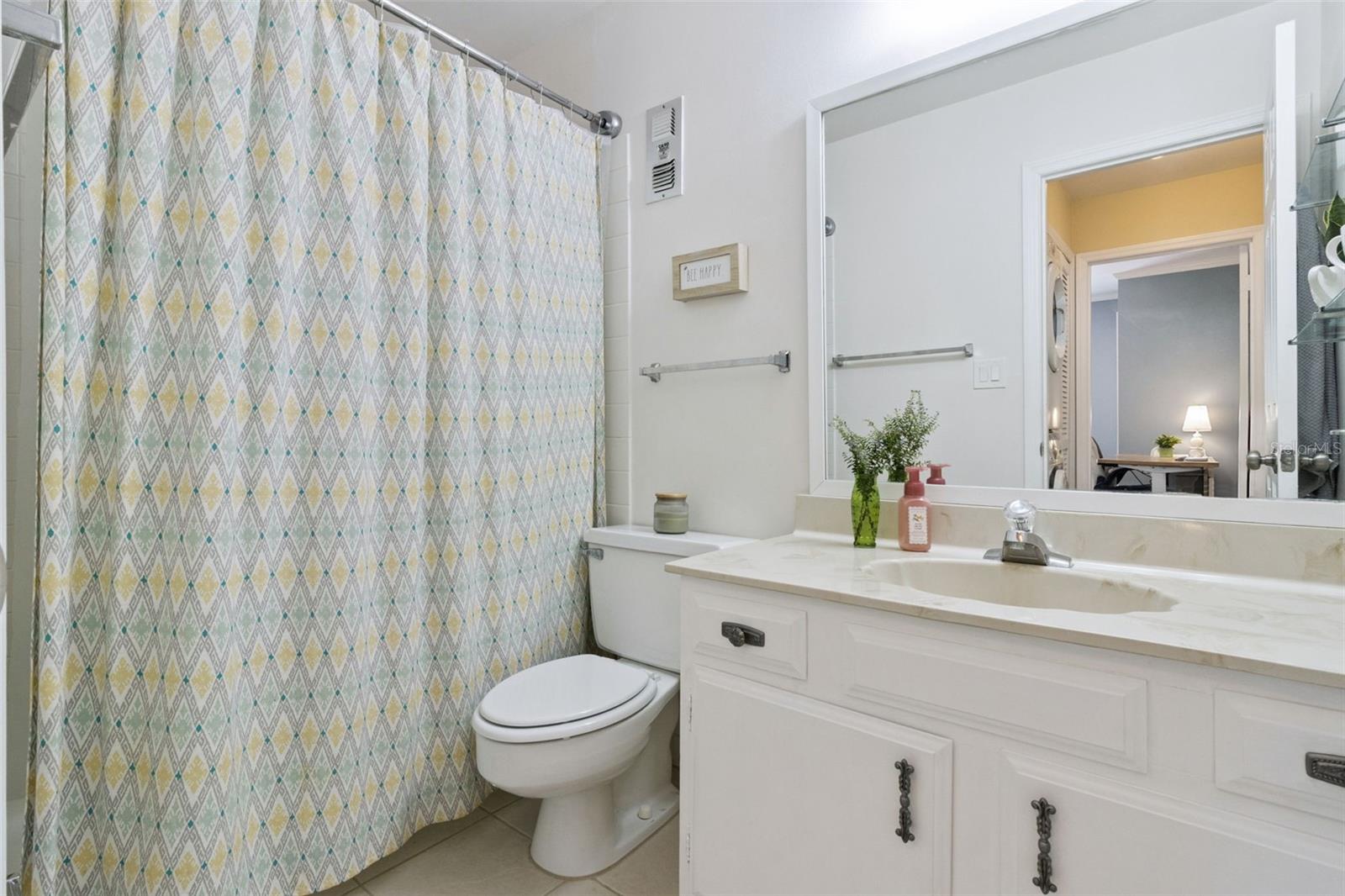 The second bathroom features a marble vanity with integrated sink and tub with shower.