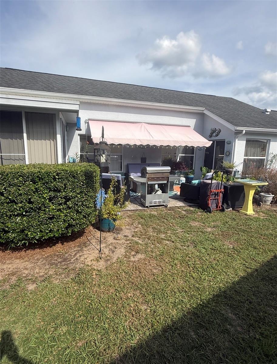 other side yard with grilling and relaxing area under sun shade