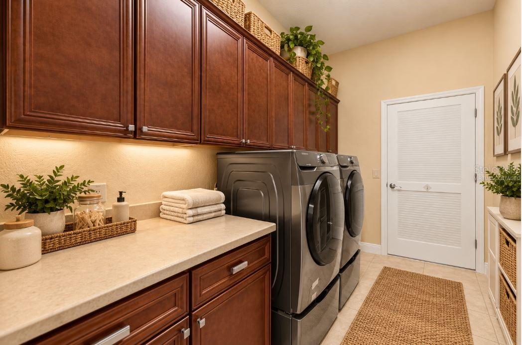 Virtually staged Indoor Laundry Room with Custom Cabinetry, Utility Sink, and Folding Counter.