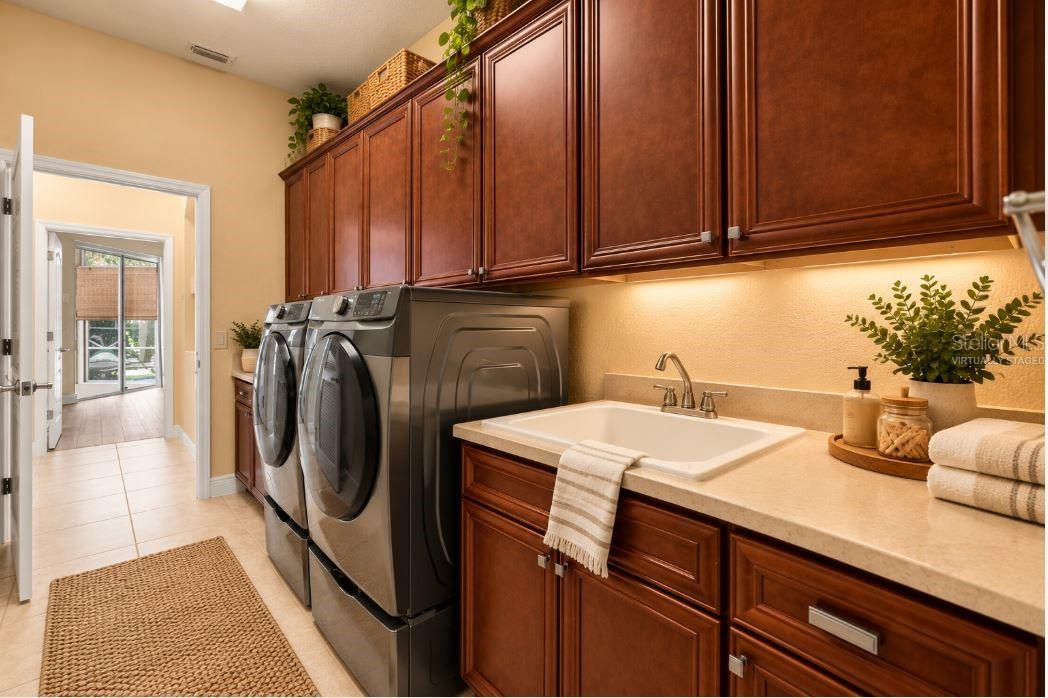 Virtually staged Indoor Laundry Room with Custom Cabinetry, Utility Sink, and Folding Counter.