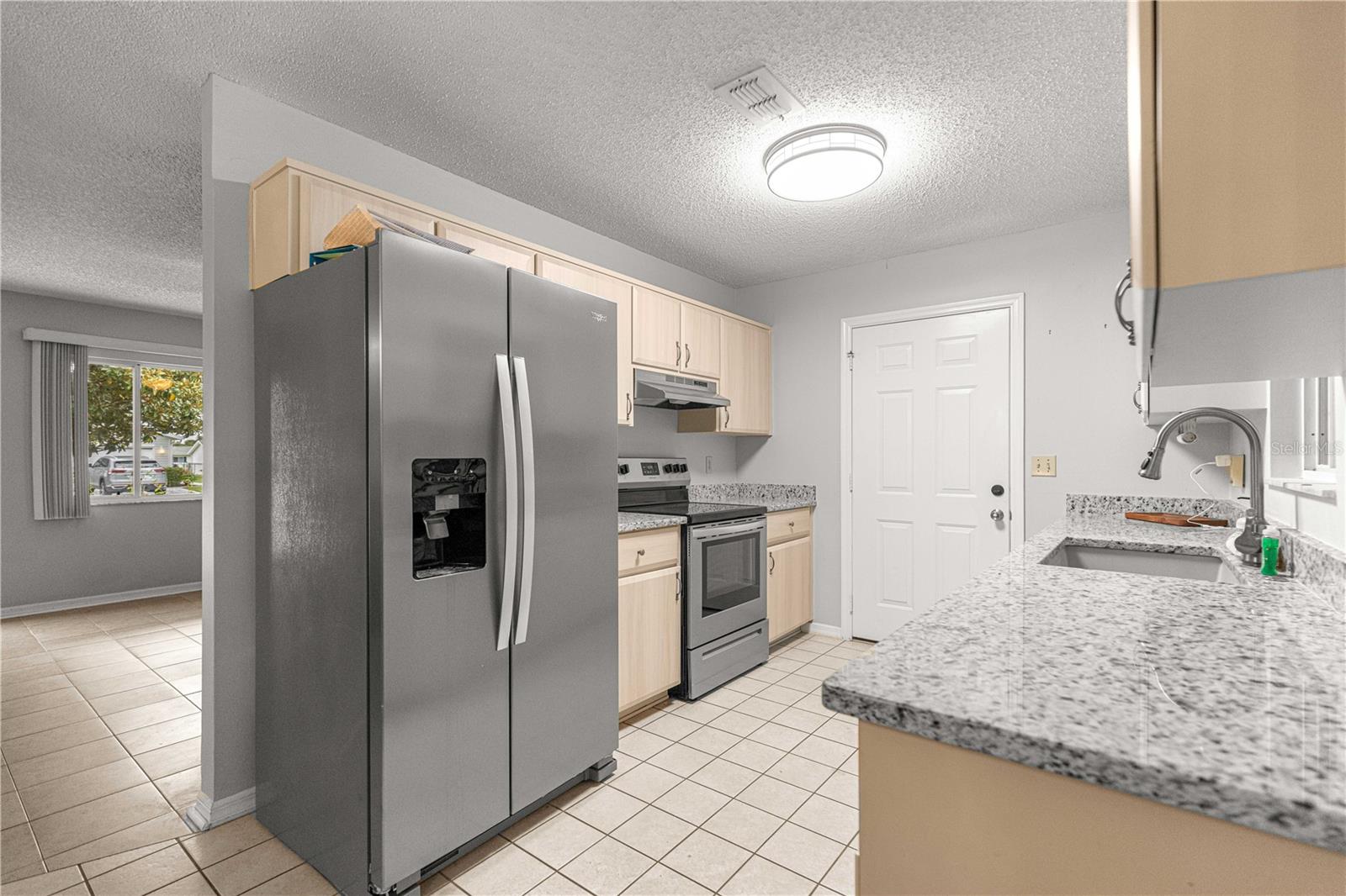 KITCHEN STAINLESS STEEL APPLIANCES TO FRONT LIVING ROOM WINDOW VIEW