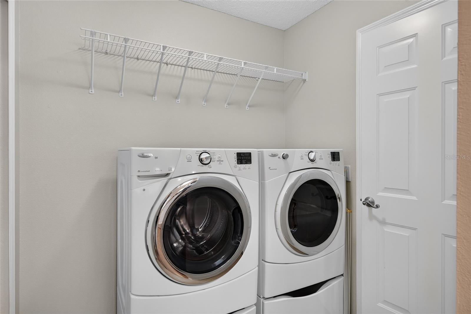 INDOOR LAUNDRY - Adjacent to the kitchen and features a front-load WASHER & DRYER with a storage shelf above the appliances. Note door (R) provides direct access to the 1.5 CAR GARAGE.