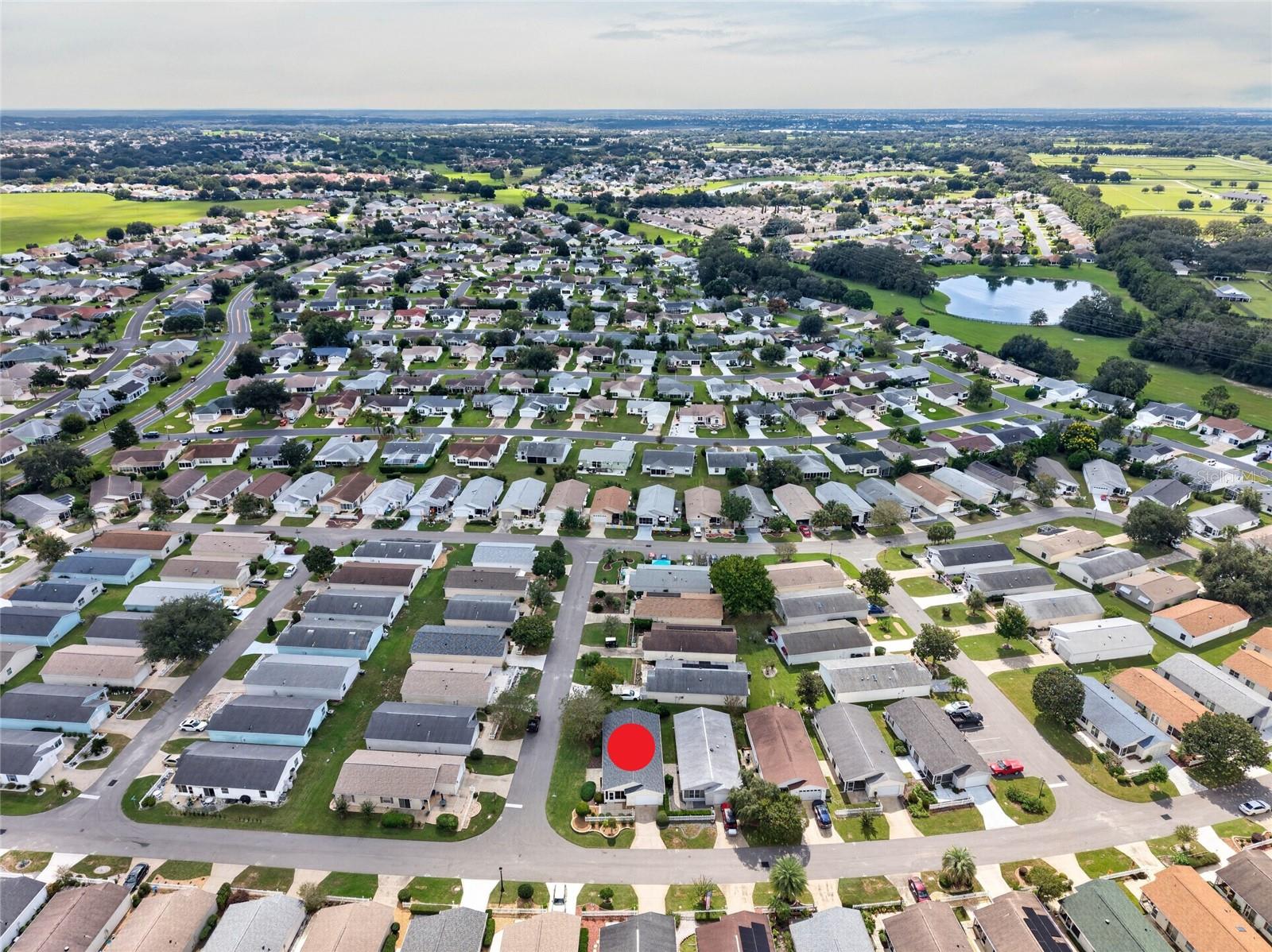 AERIAL  Looking South  CORNER LOT villa (marked) in SANTO DOMINGO, with Cazares Avenue (left), the Sharon L. Morse Owl Preserve (deep left) and golf-cart access to Lake Sumter Landing (deep center).