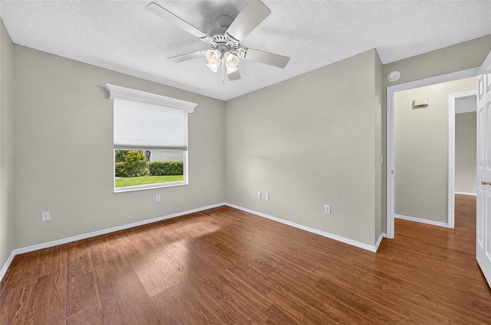 Another view of BEDROOM #2 - Shows white wooden window cornice and a ceiling fan with light. Note doorway (R) that shows connection to HALLWAY and main living area.