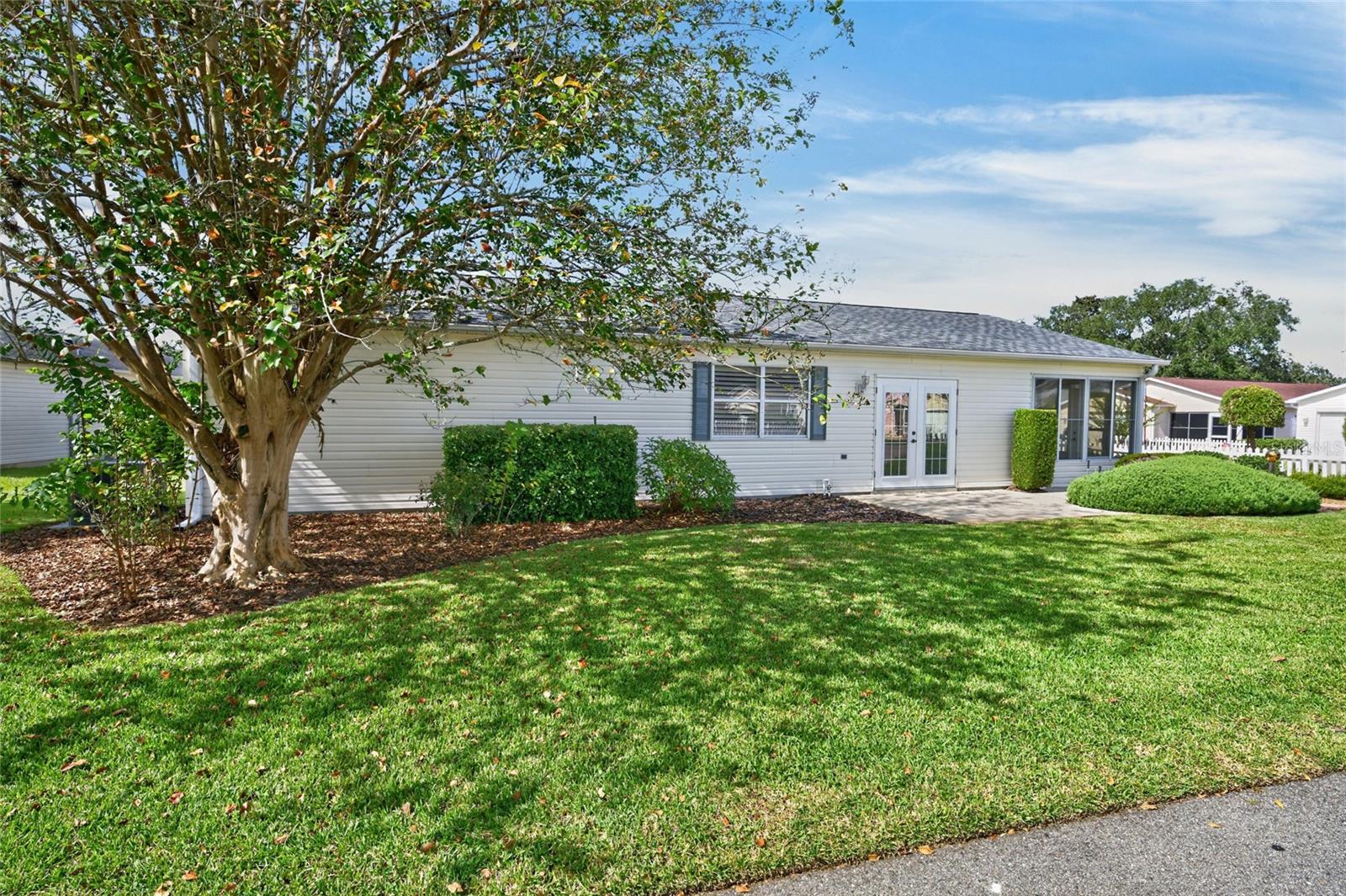 SIDE PATIO (eastern side of villa) - View of double FRENCH DOORS entry and side view of ENCLOSED LANAI.