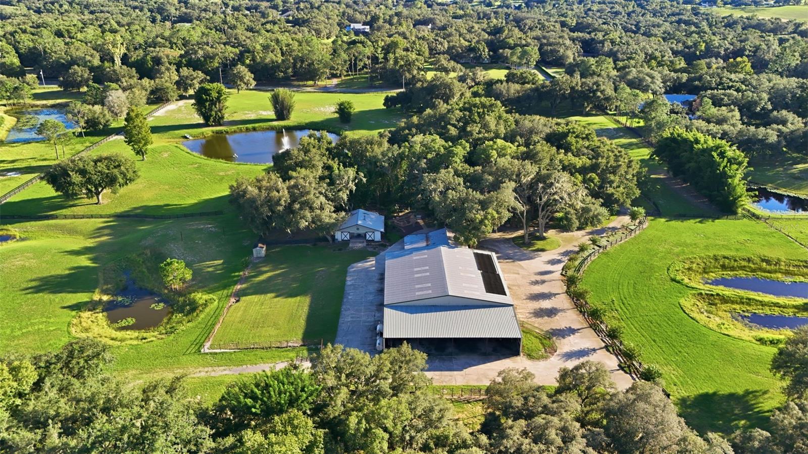 aerial of property, horse barn and front pond with fountain