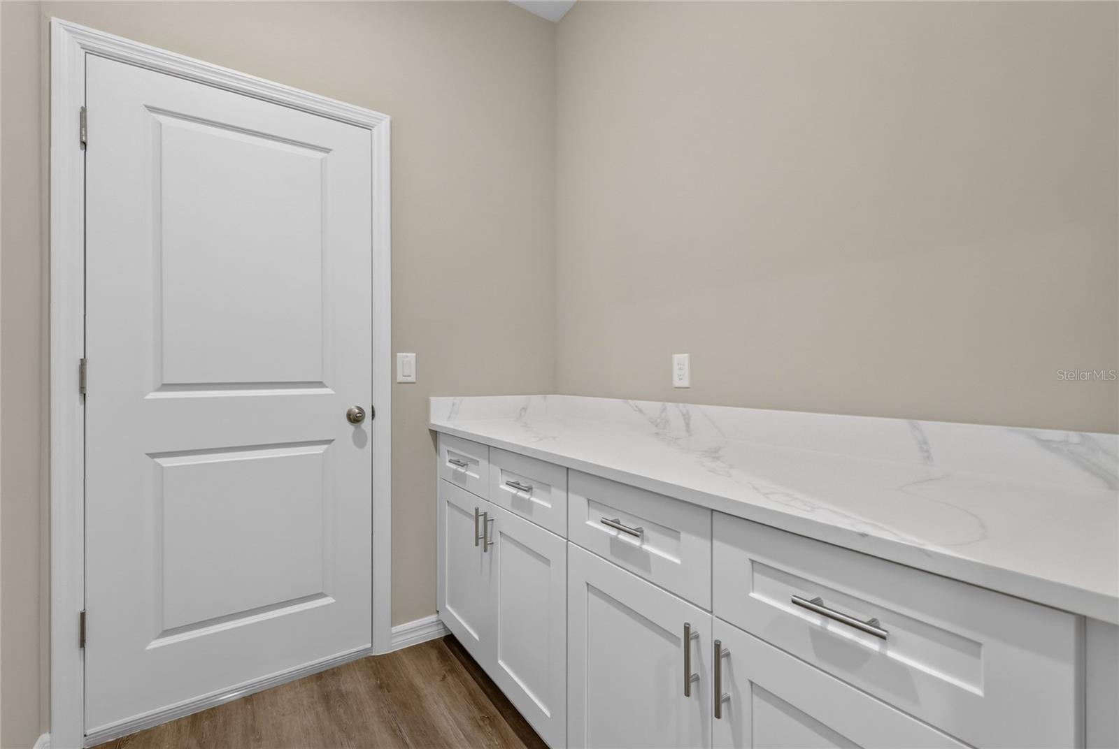 Folding area with cabinets and door leads to garage