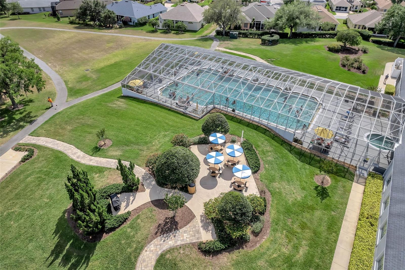 Pool with shaded picnic tables.