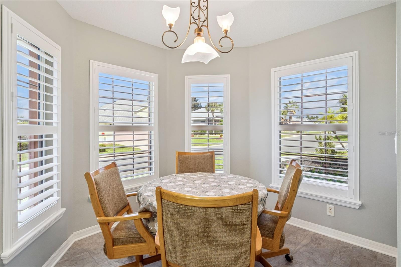 Eat-in nook wrapped in windows and plantation shutters.