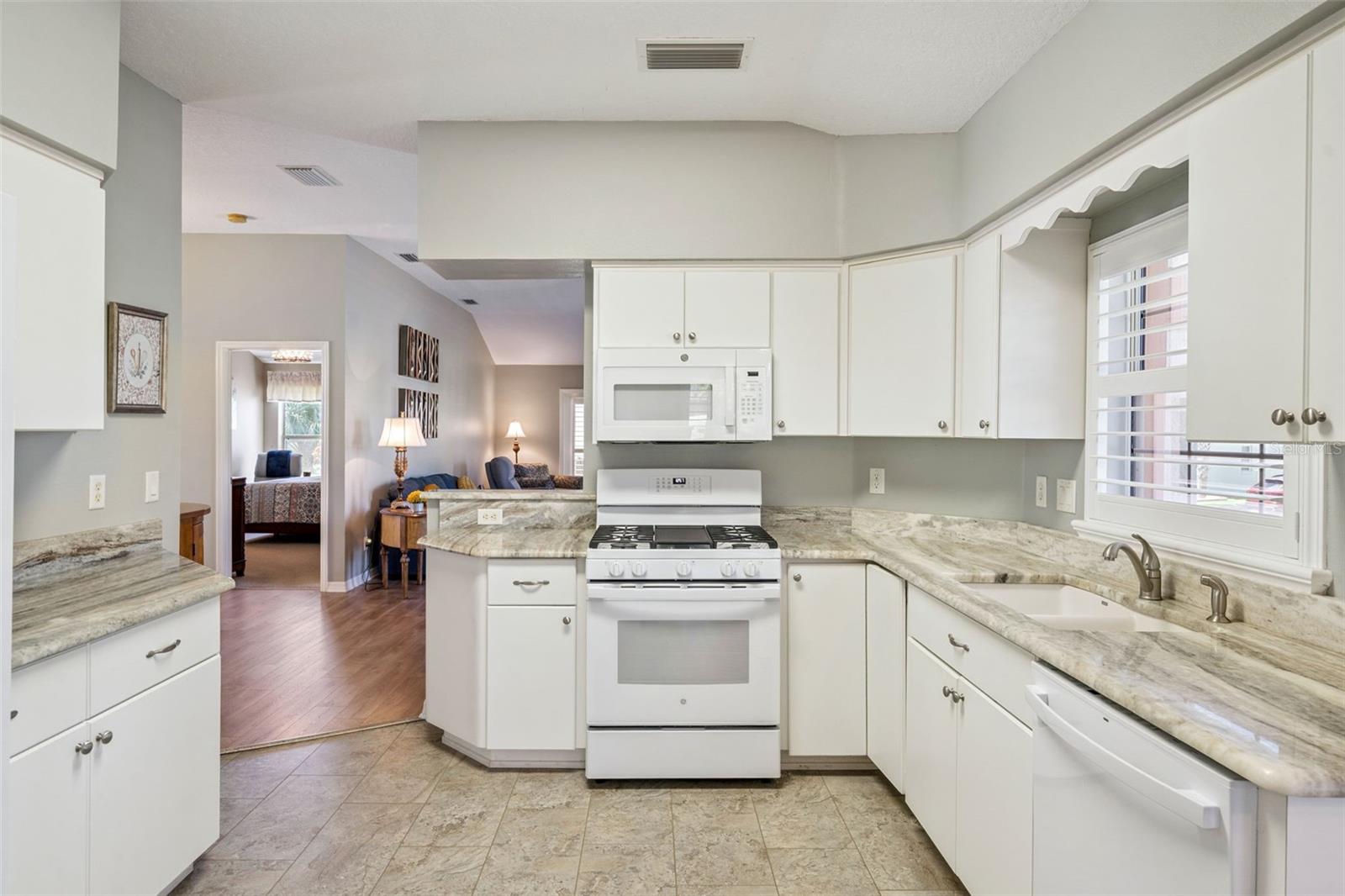Kitchen with granite counters, white cabinetry and appliances from 2024. Kitchen with granite counters, white cabinetry and appliances from 2024.