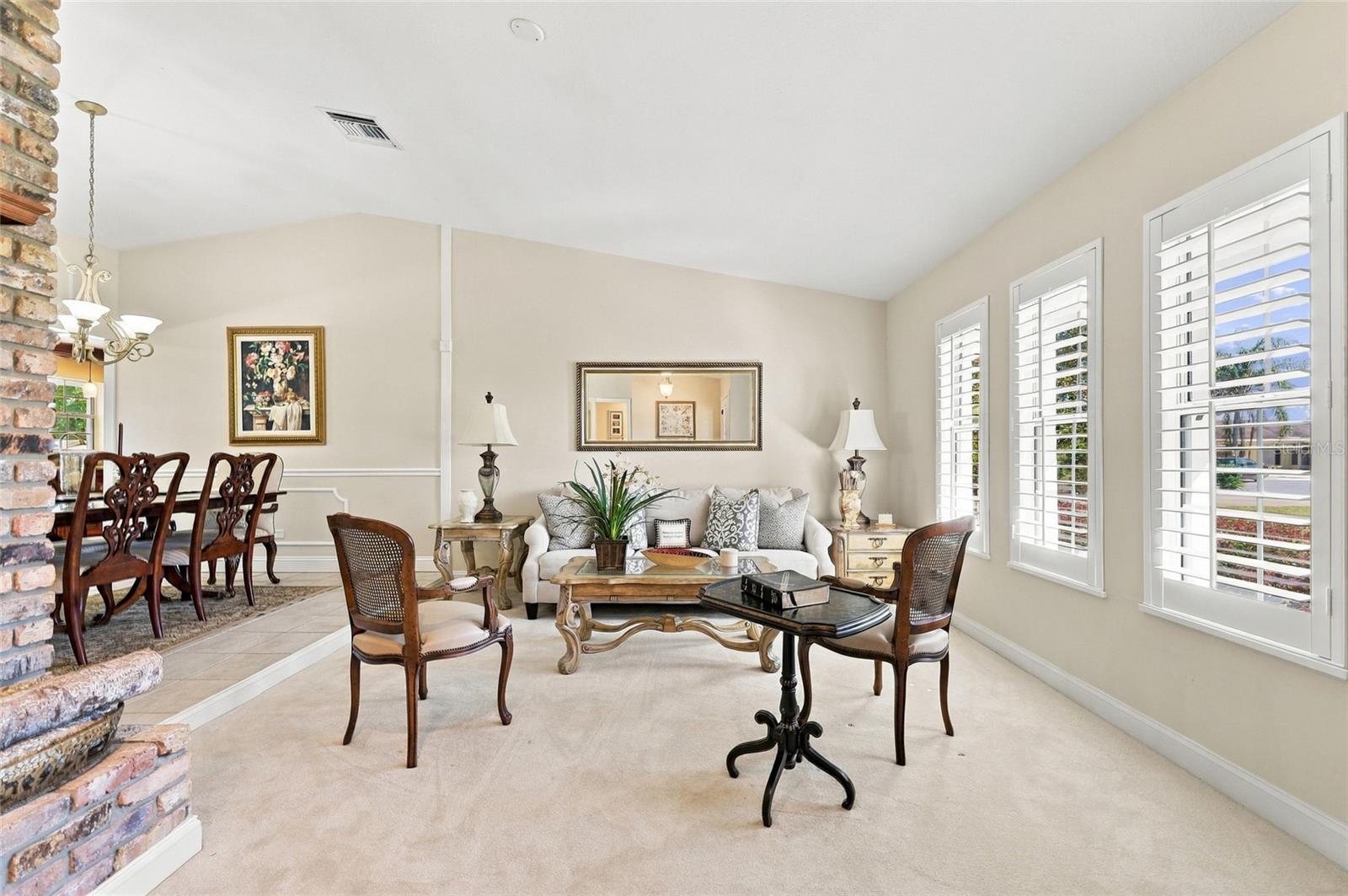 Living Room with plantation shutters & wood burning fireplace