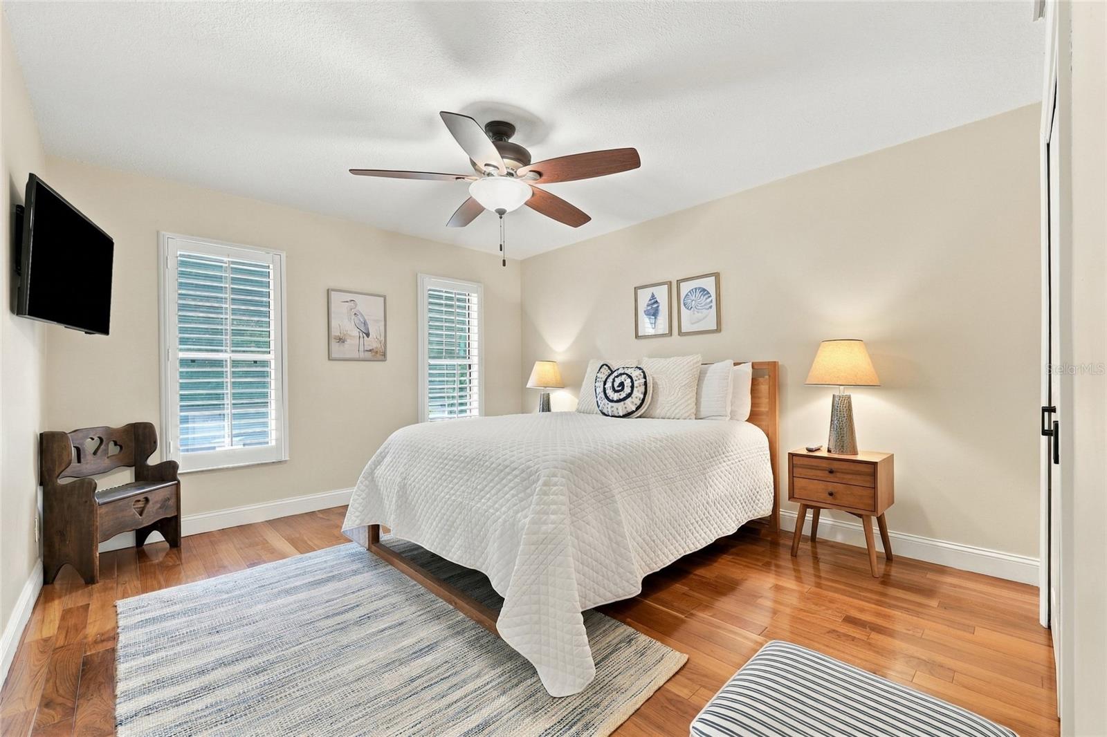 2nd guest bedroom with teak engineered floors & plantation shutters