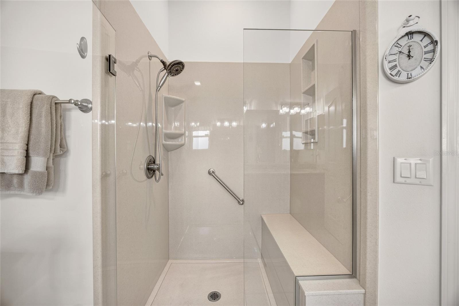 A glass-enclosed shower and neutral finishes complete this inviting space.