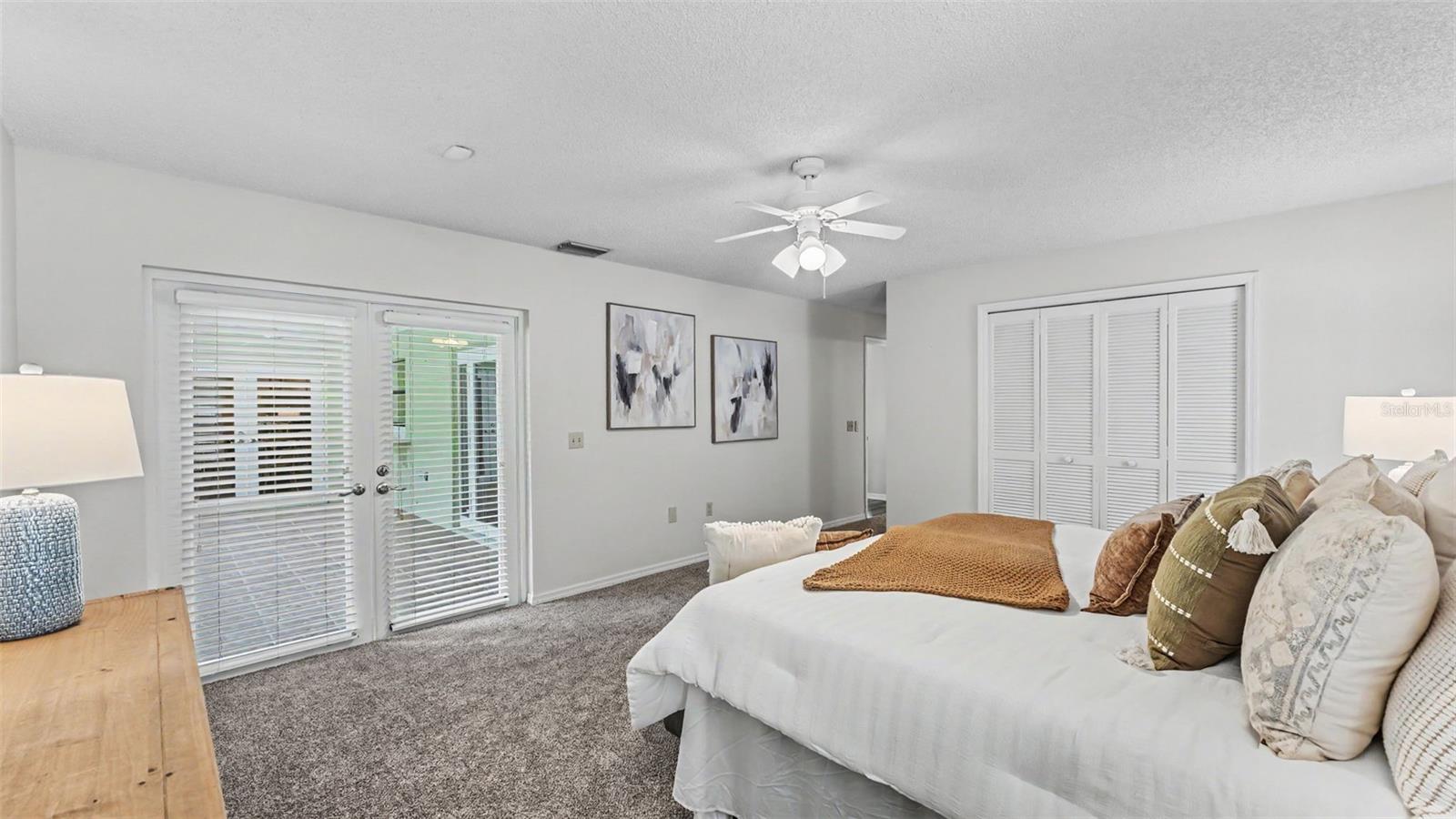 Primary bedroom suite with French doors to the covered screened patio