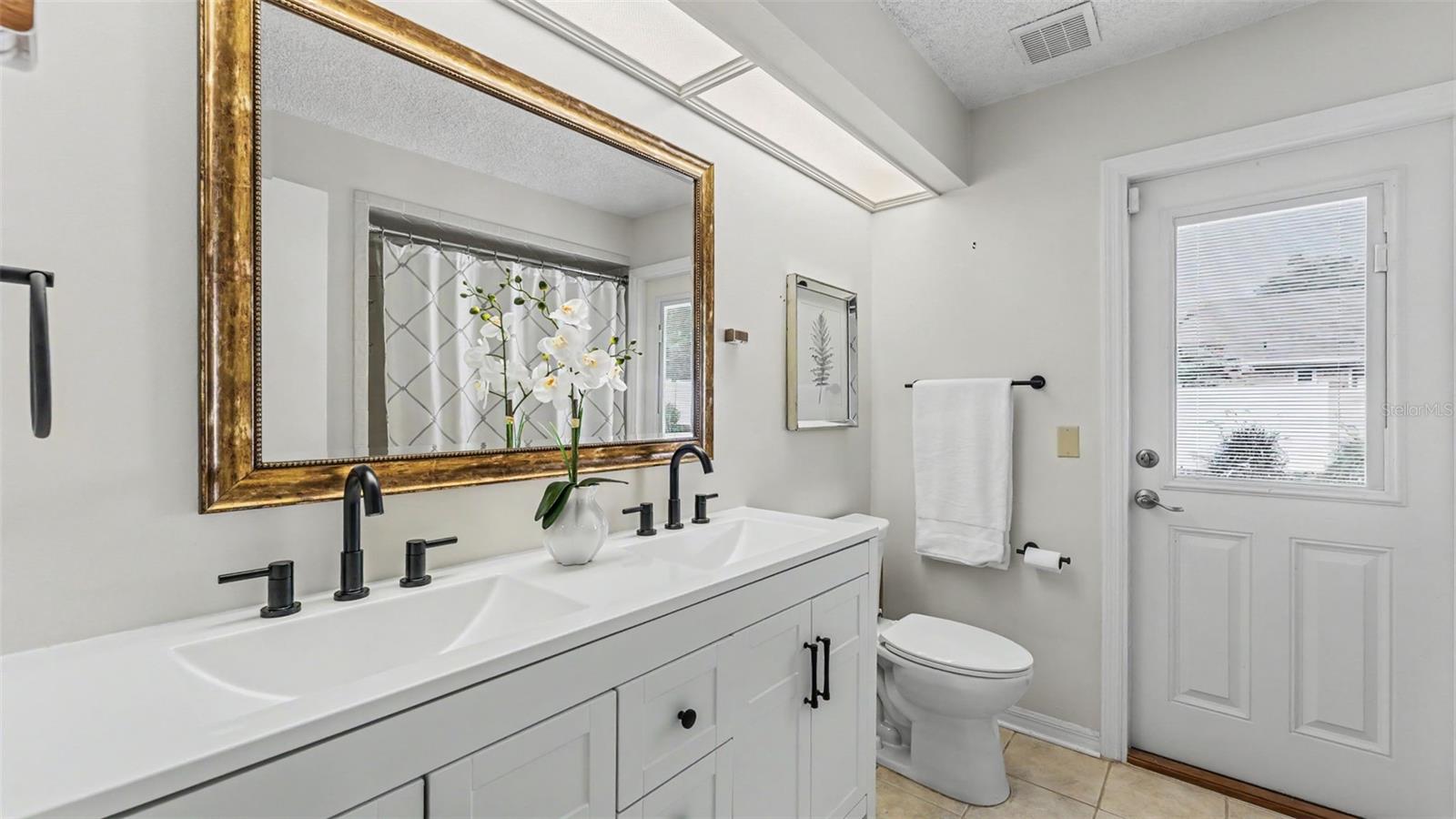 hall bathroom with new double vanity and door out to the paver patio