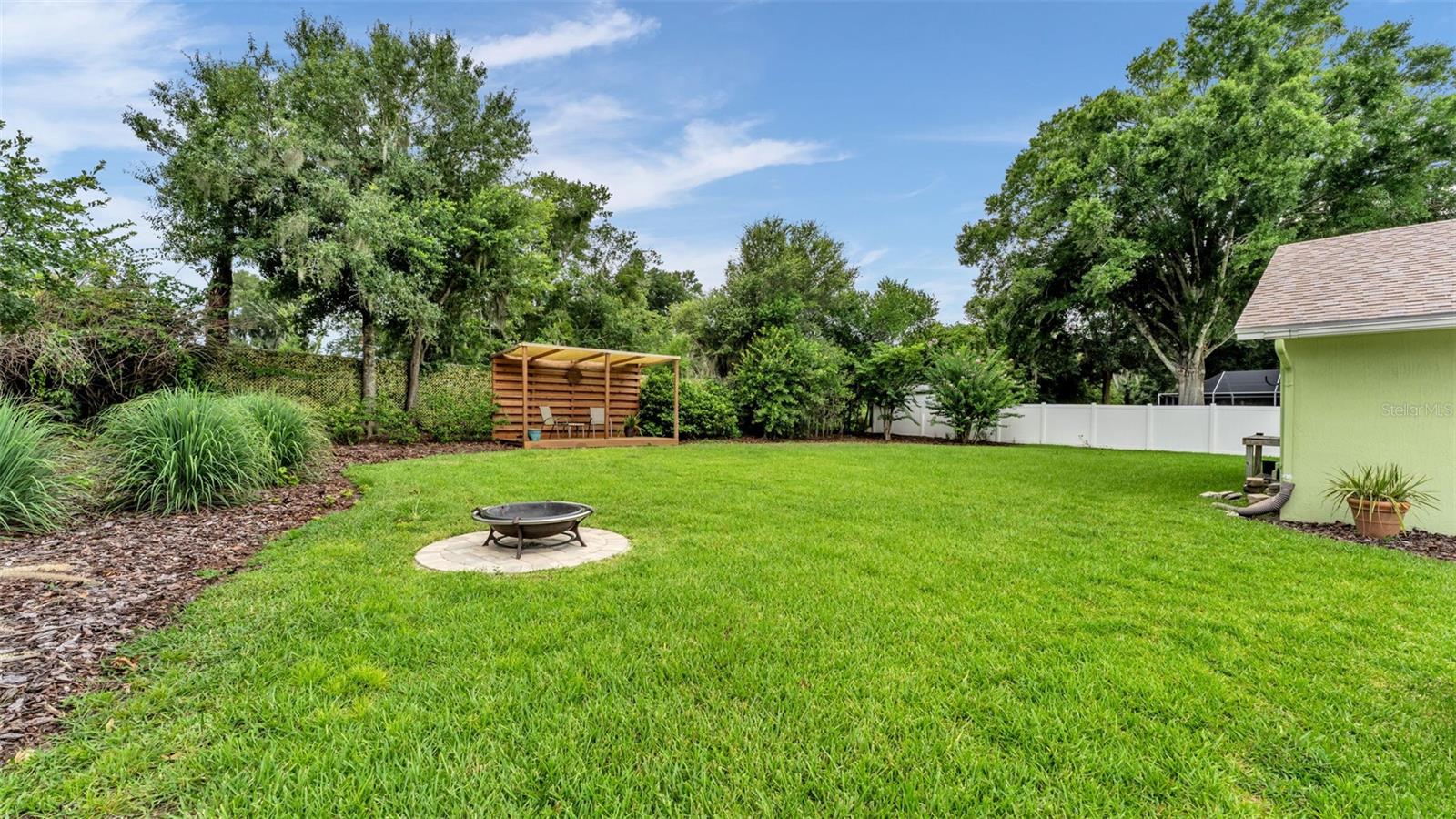 expansive fenced backyard with firepit