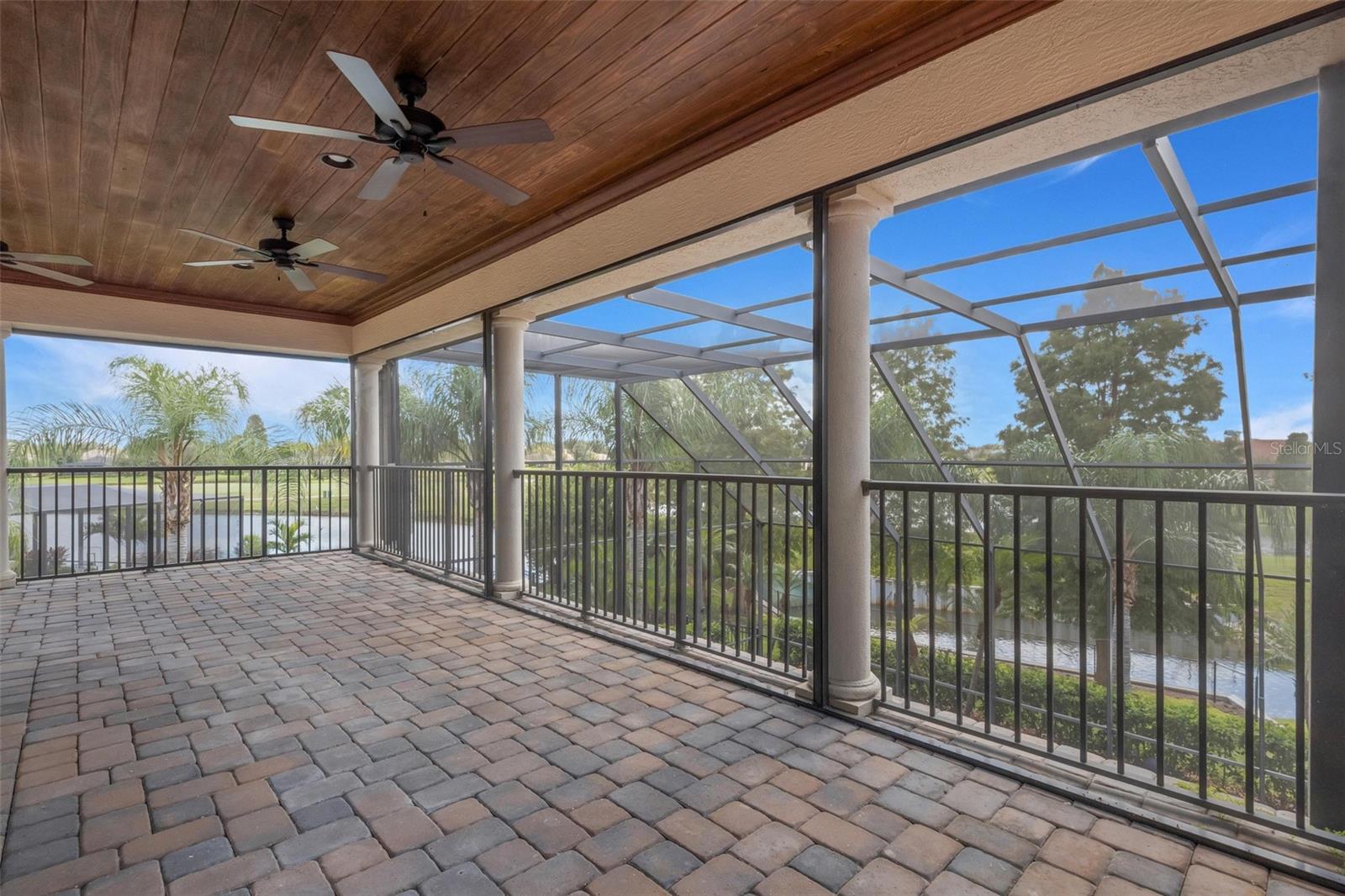 The large screen enclosed balcony overlooks the pool below and the golf course and waterways beyond.