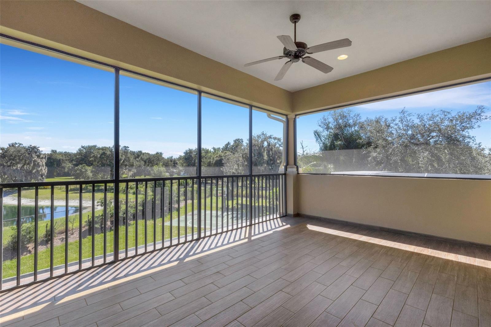 The screen enclosed balcony affords panoramic views that extend well beyond the backyard.