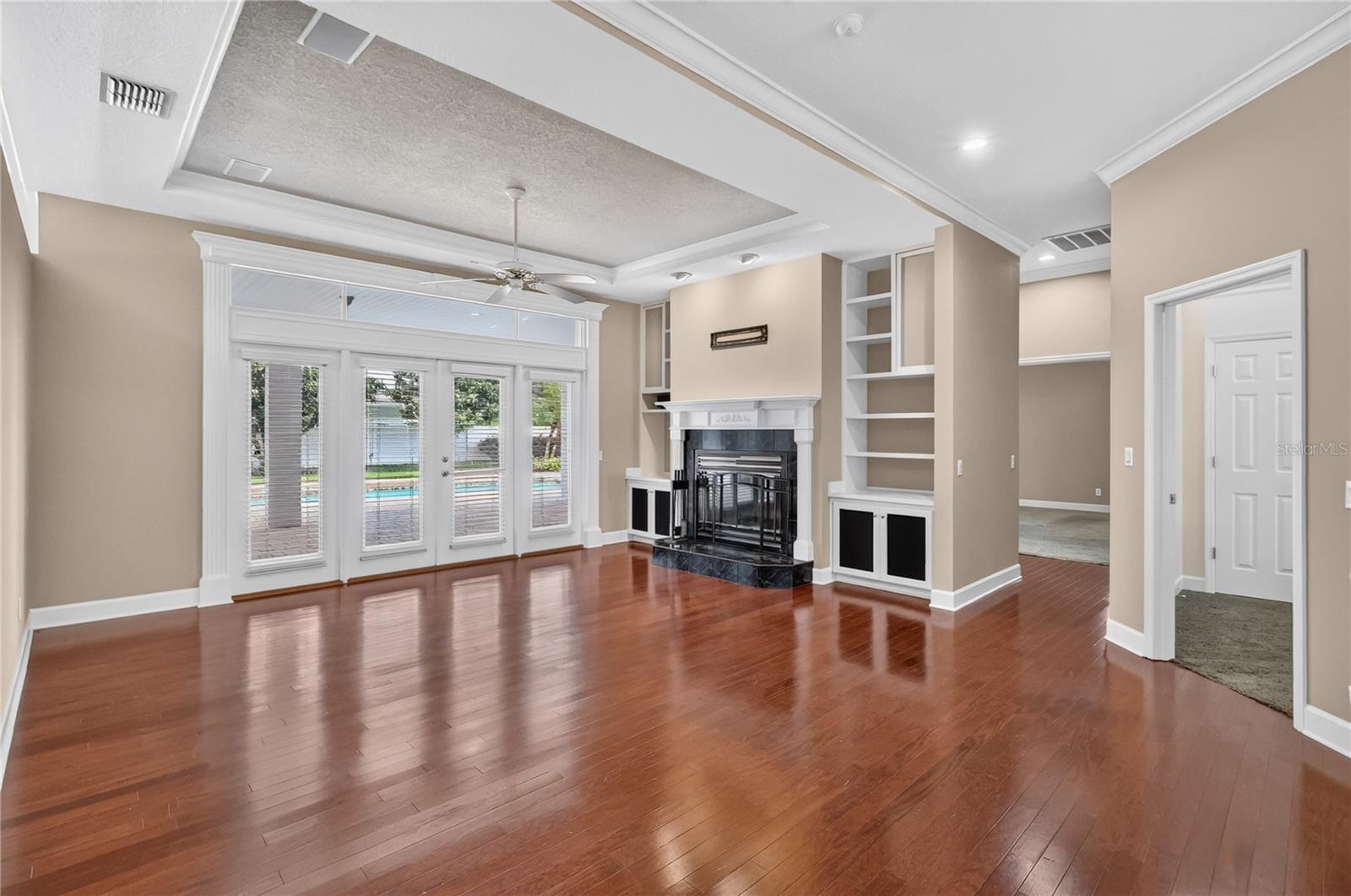 Family Room with Fireplace and Built In Shelving over looking the Pool Family Room with Fireplace and Built In Shelving over looking the Pool