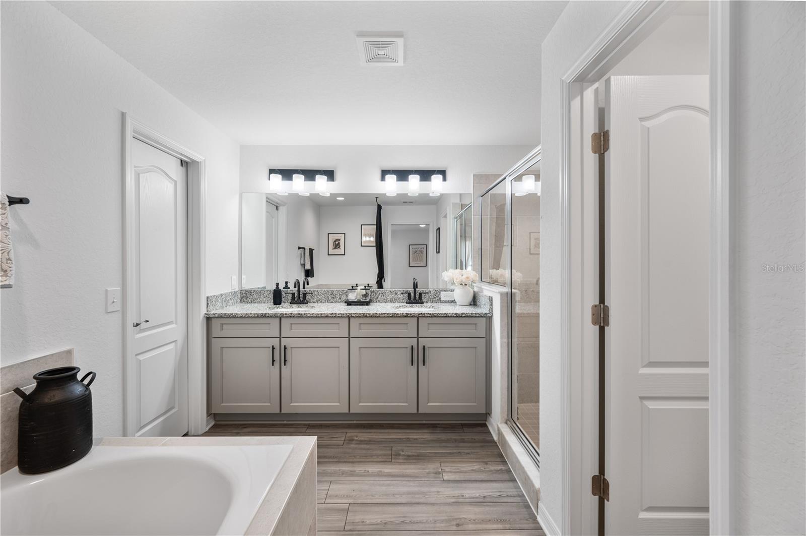 The Primary en suite bathroom features a large walk in closet, walk-in shower, soaking tub & private commode area & oversized dual sinks vanity