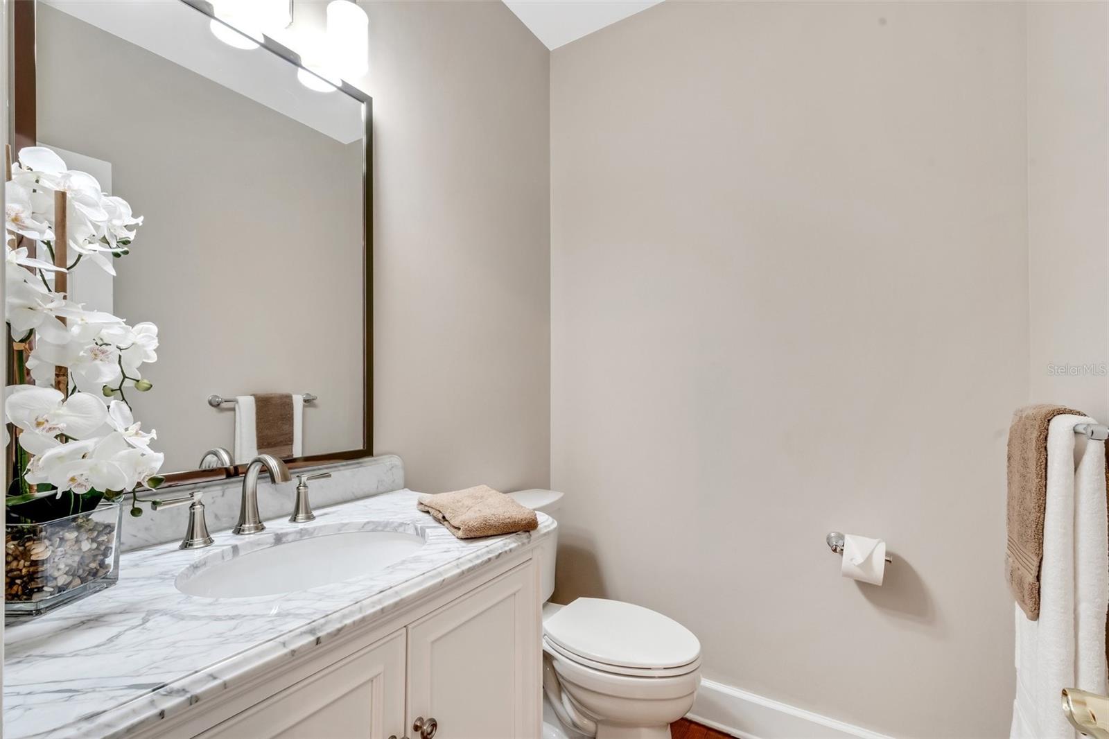 Downstairs half bath is located just off the kitchen .