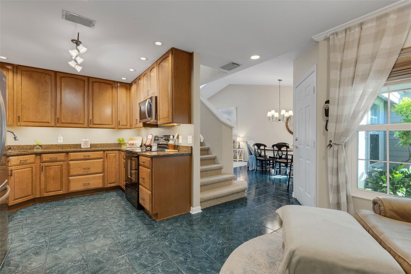 The kitchen boasts wood cabinets and granite countertops.