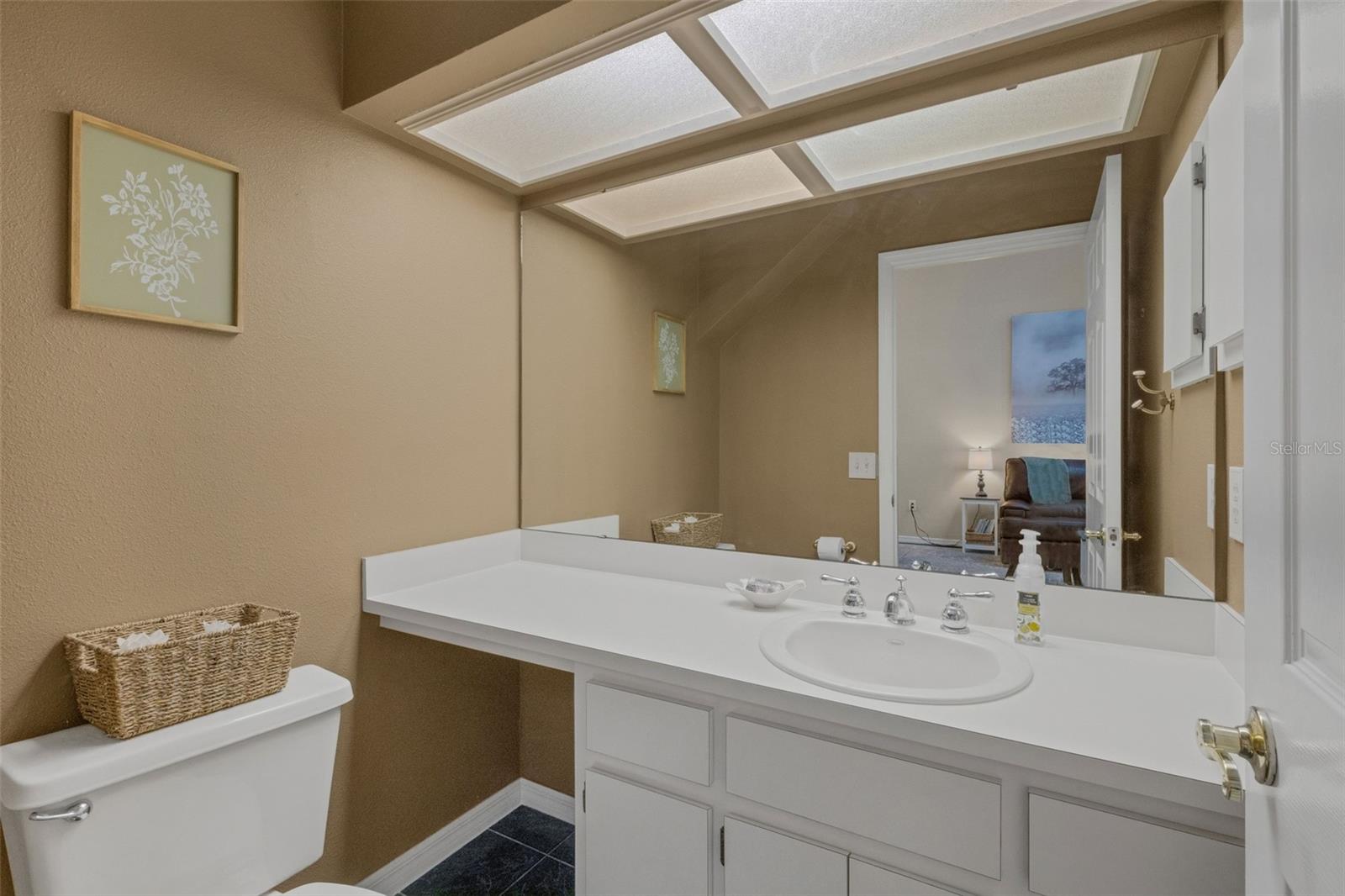 Tucked into an alcove under the stairs is the guest powder room.