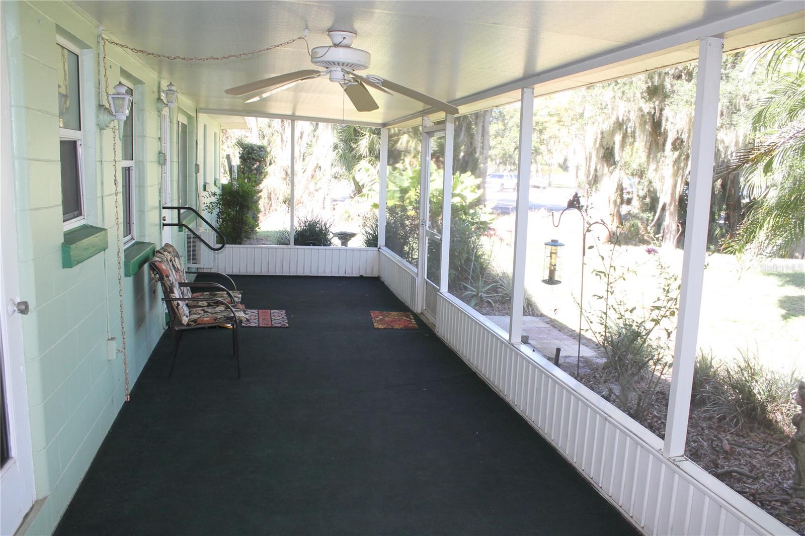 Screen porch in the rear of the house overlooking the back yard and Lake