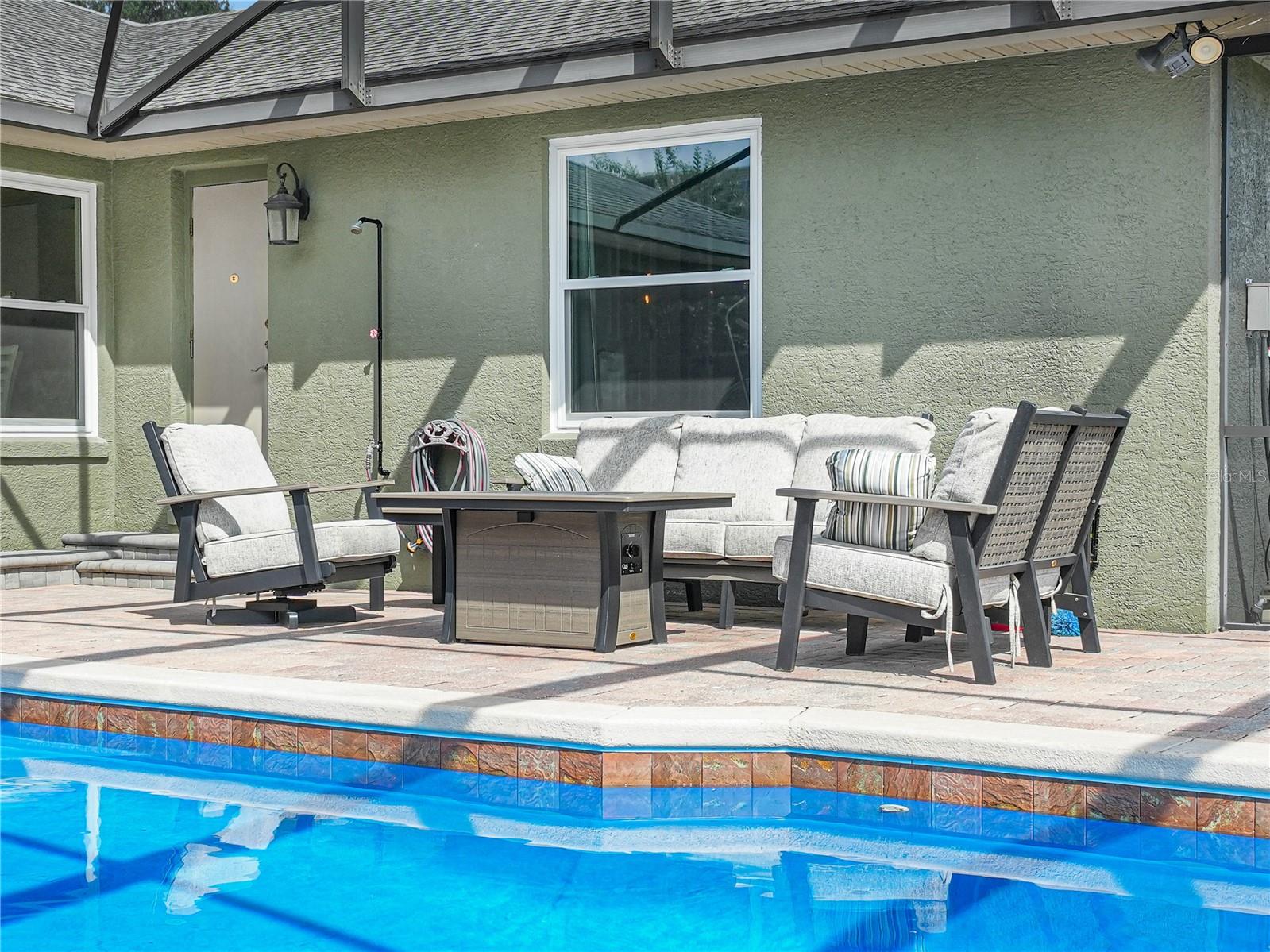 Another sitting area poolside next to door for the pool bathroom