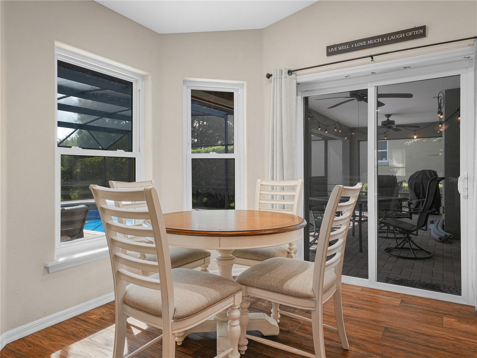 Eating area in kitchen overlooks pool and back yard for morning time together with the family
