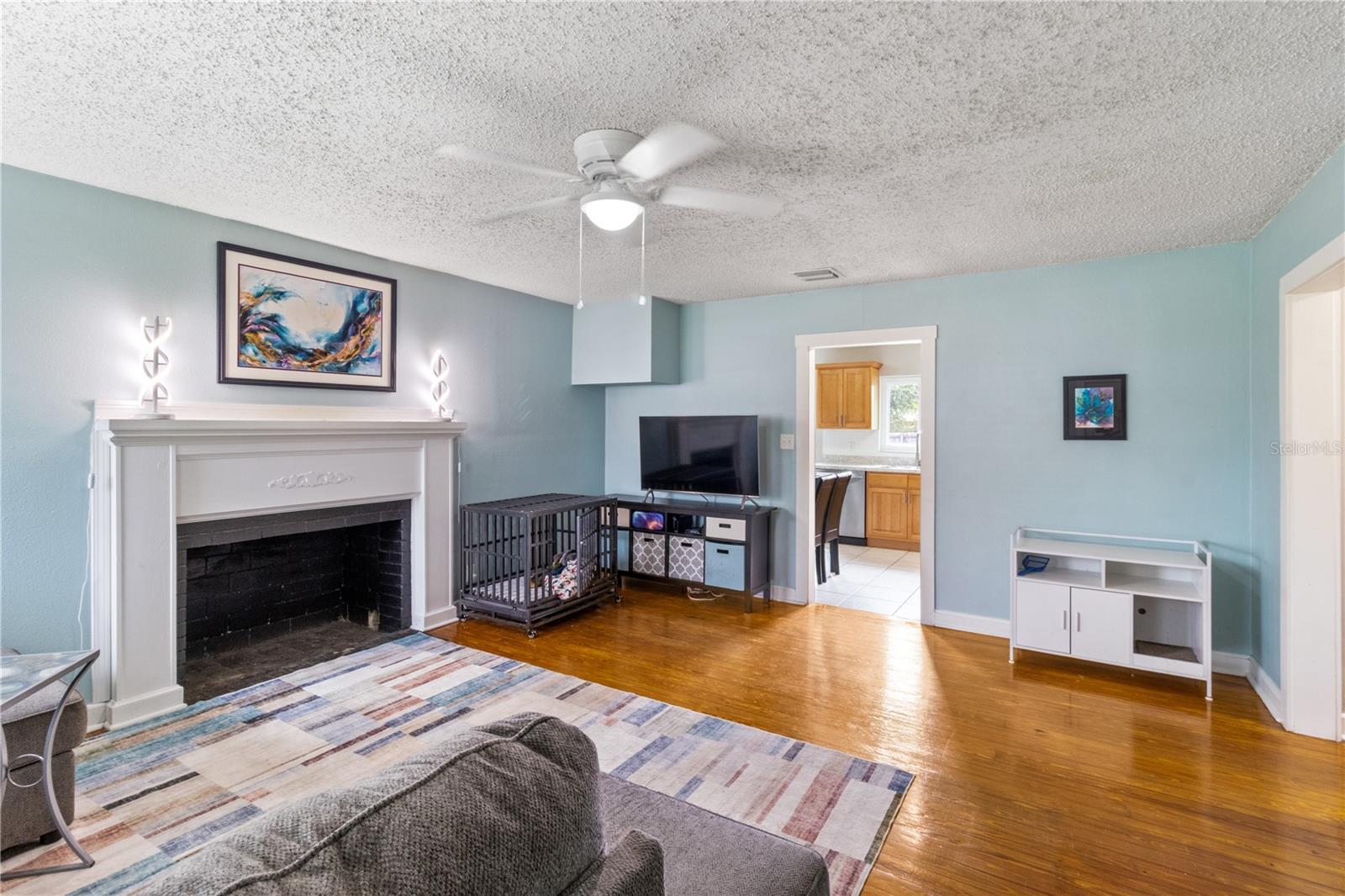 Living room with original hardwoods and decorative fireplace
