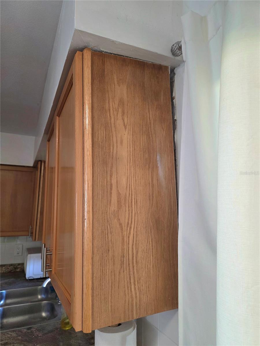 Slight separation of cabinet from wall Slight separation of cabinet from wall