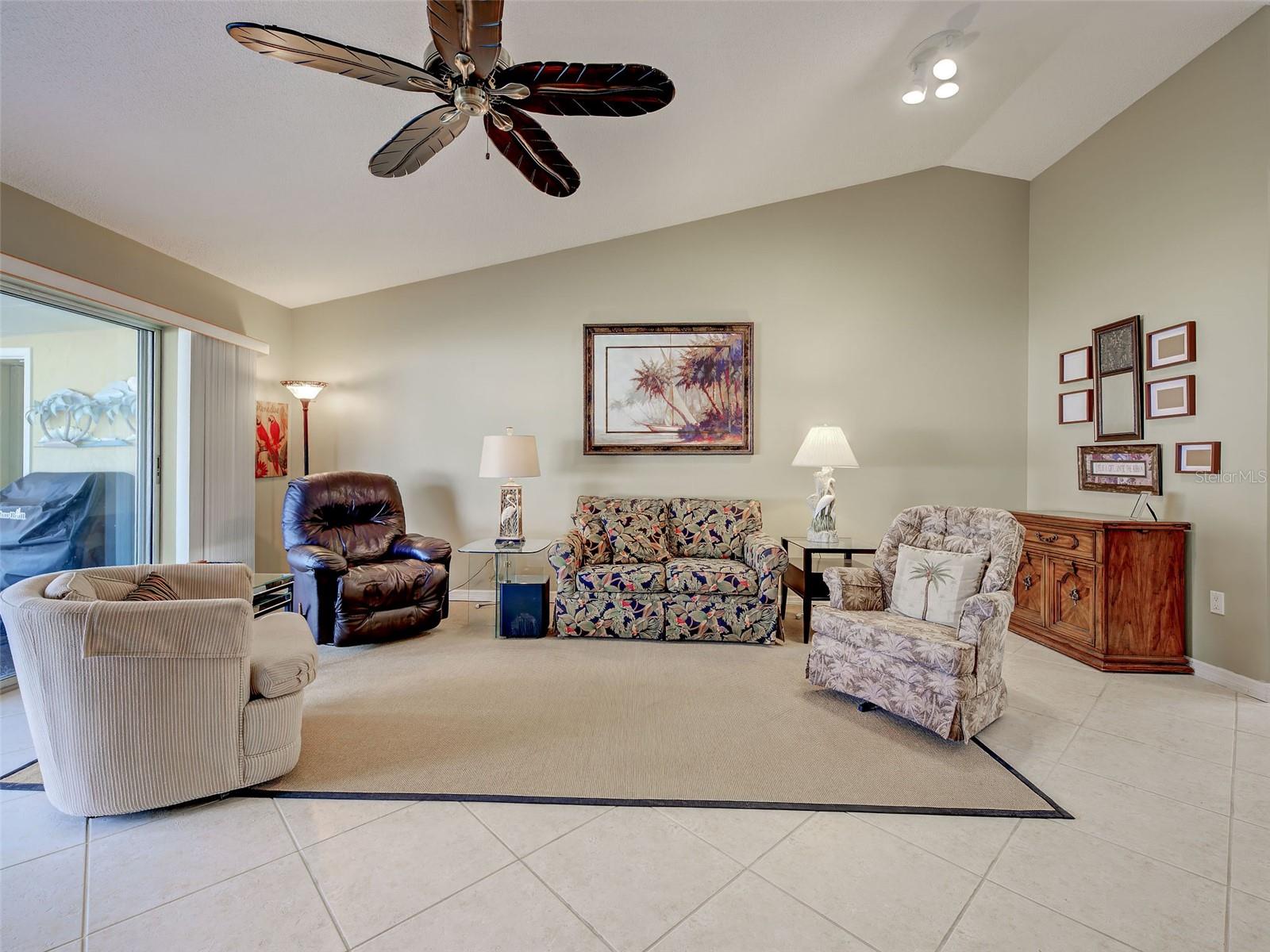 lLarge living room with ceiling fan, cathedral ceiling