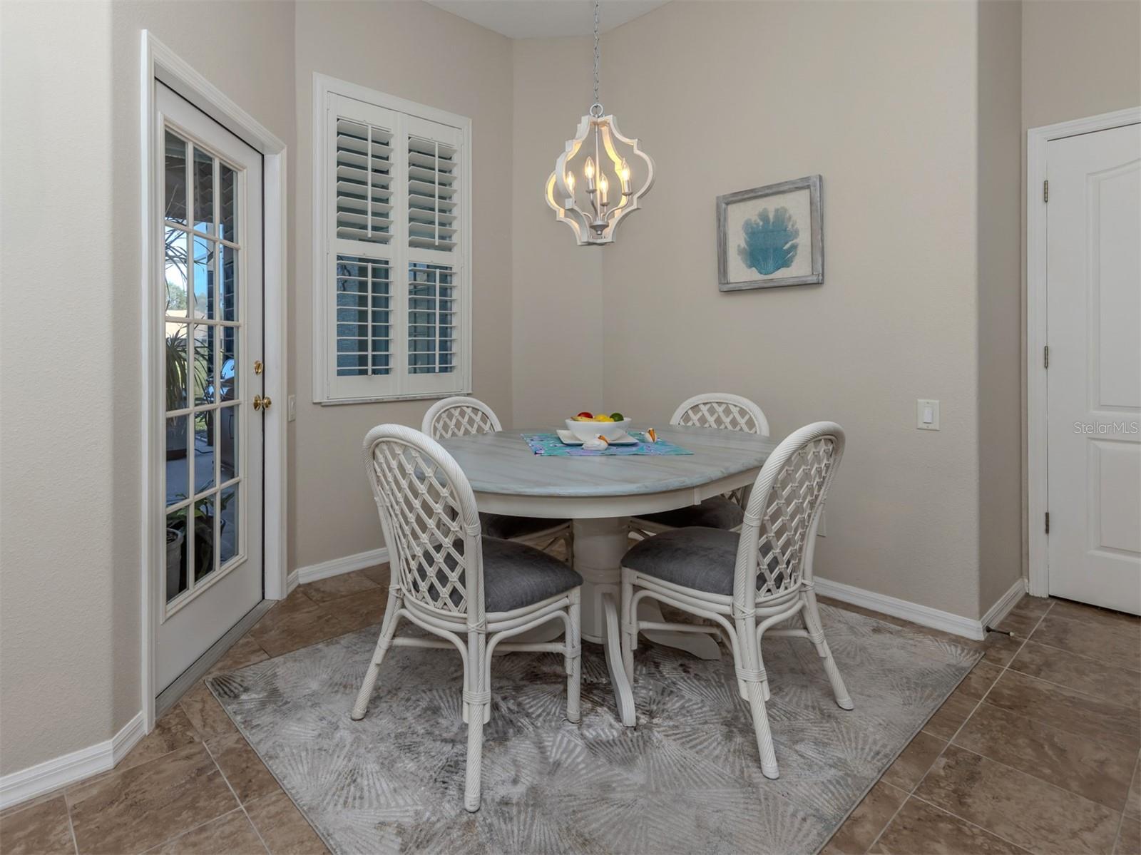 A charming breakfast nook with a delightful view! The perfect little spot to enjoy your morning coffee or a casual meal while overlooking the extended lanai and peaceful lake views beyond!