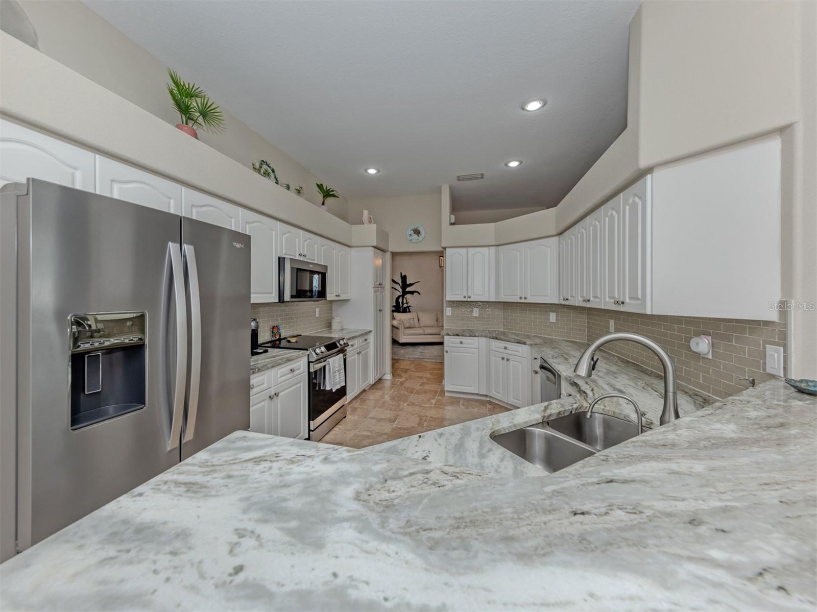 A spacious, beautifully updated kitchen featuring gorgeous granite countertops, crisp white cabinetry, sleek stainless steel appliances, and recessed lighting with dimmer controls to create the perfect ambiance for cooking, gathering, and entertaining! A spacious, beautifully updated kitchen featuring gorgeous granite countertops, crisp white cabinetry, sleek stainless steel appliances, and recessed lighting with dimmer controls to create the perfect ambiance for cooking, gathering, and entertaining!
