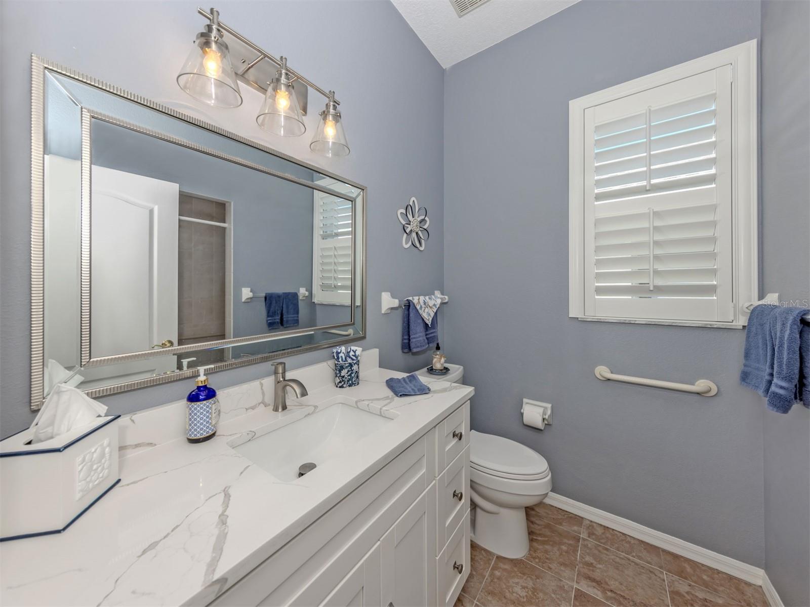 A little luxury for everyone! This beautifully updated guest bathroom shines with a gorgeous quartz countertop, stylish new lighting, a lovely new mirror, and a refreshing walk-in shower. A delightful blend of elegance and comfort, perfectly situated to serve both guest bedrooms and visiting friends and family!