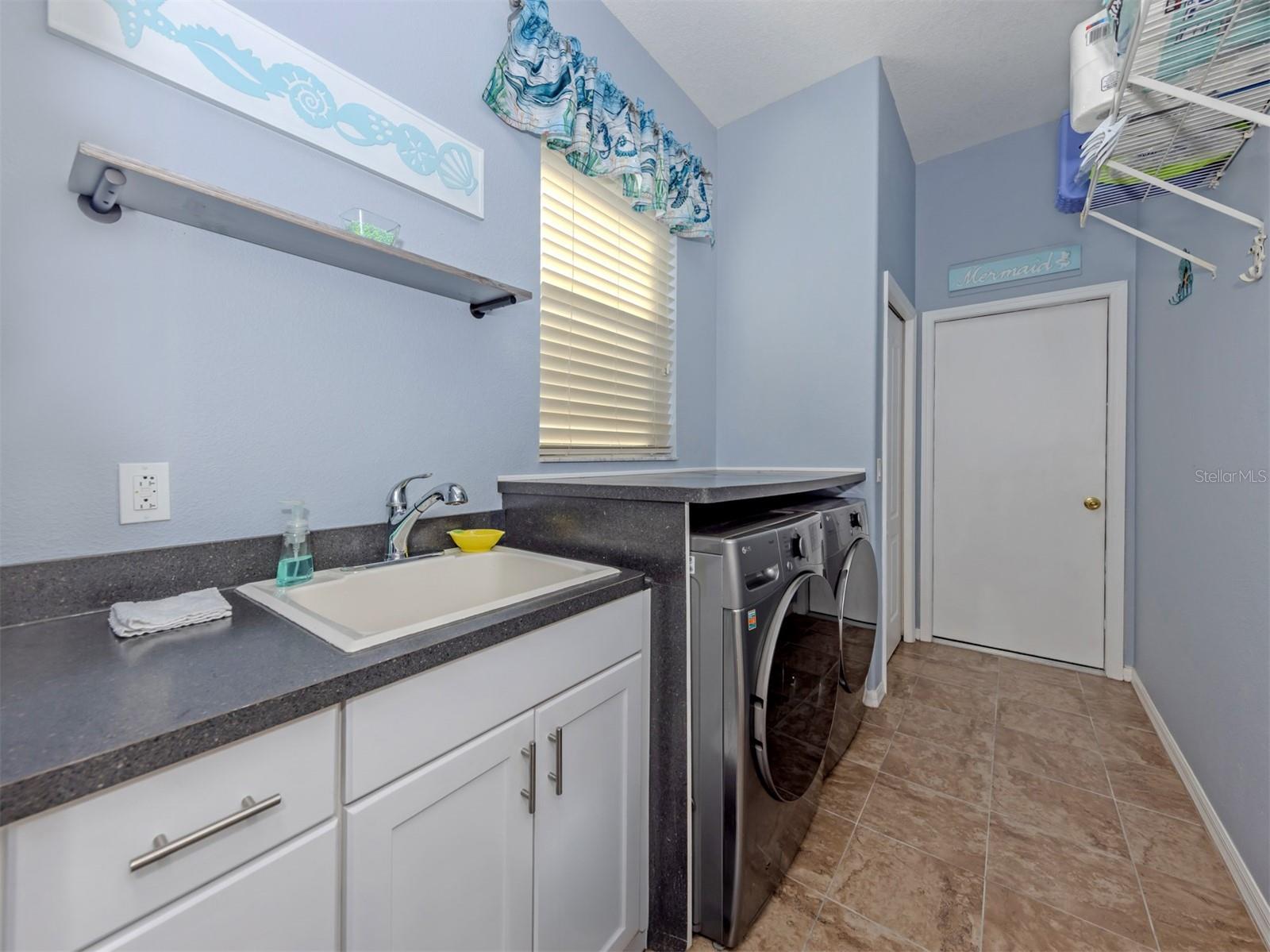 Even laundry day feels a little brighter in this wonderful, dedicated laundry room! Complete with a window for natural light, a convenient utility sink, and a storage closet, this practical yet inviting space keeps everything neatly tucked away, with direct access to the spacious two-car garage!