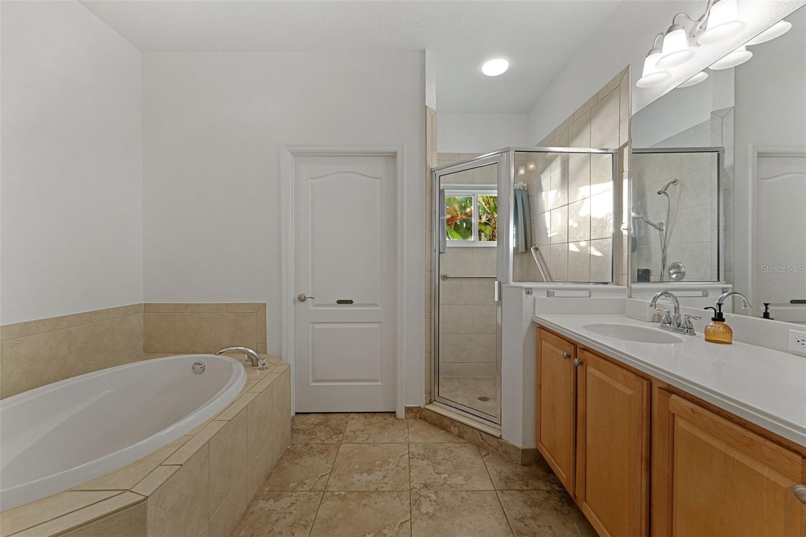 Ensuite Primary Bathroom with Soaking Garden Tub, Separate Shower Stall and Private Water Closet