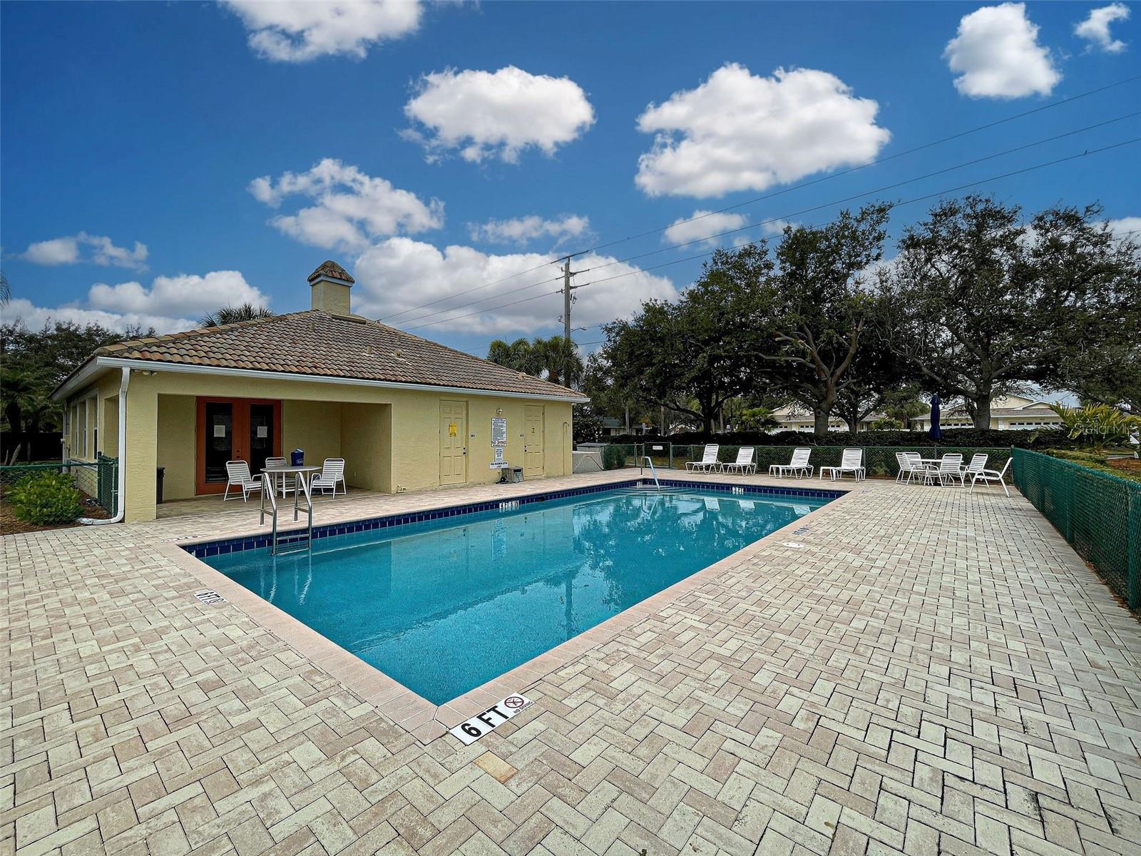 There is a large deck with pavers around the co9mmunity pool.